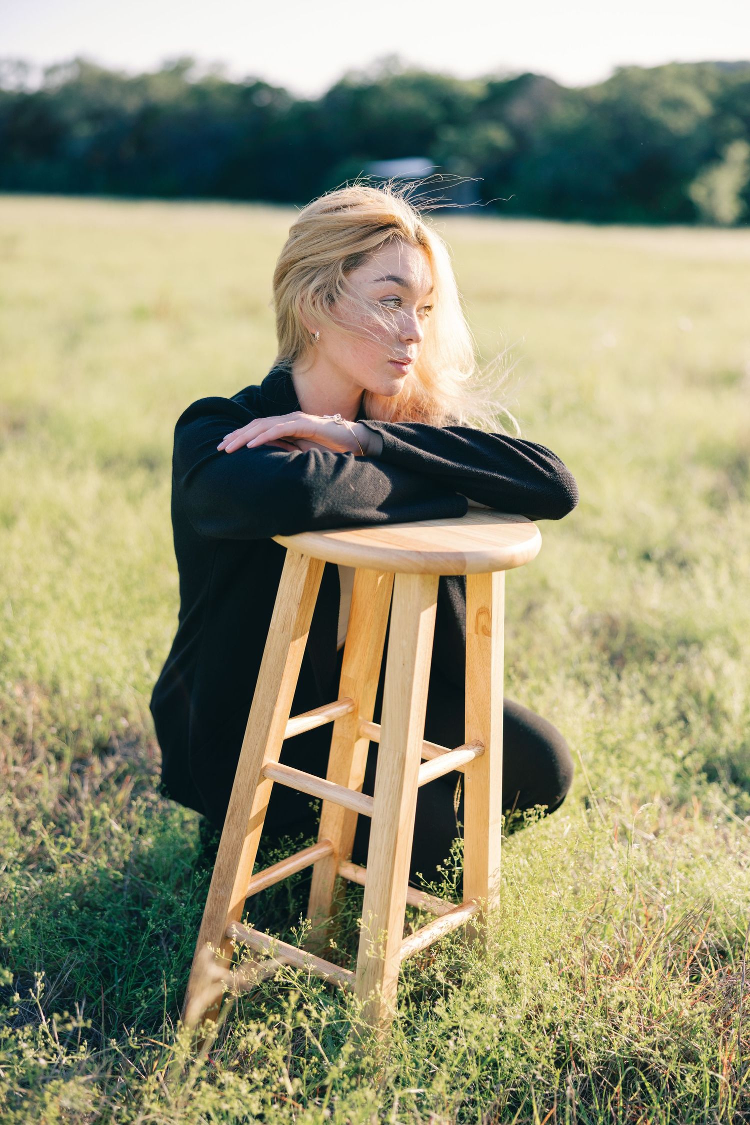 Artistic portraits with wooden stool in golden hour meadow setting.