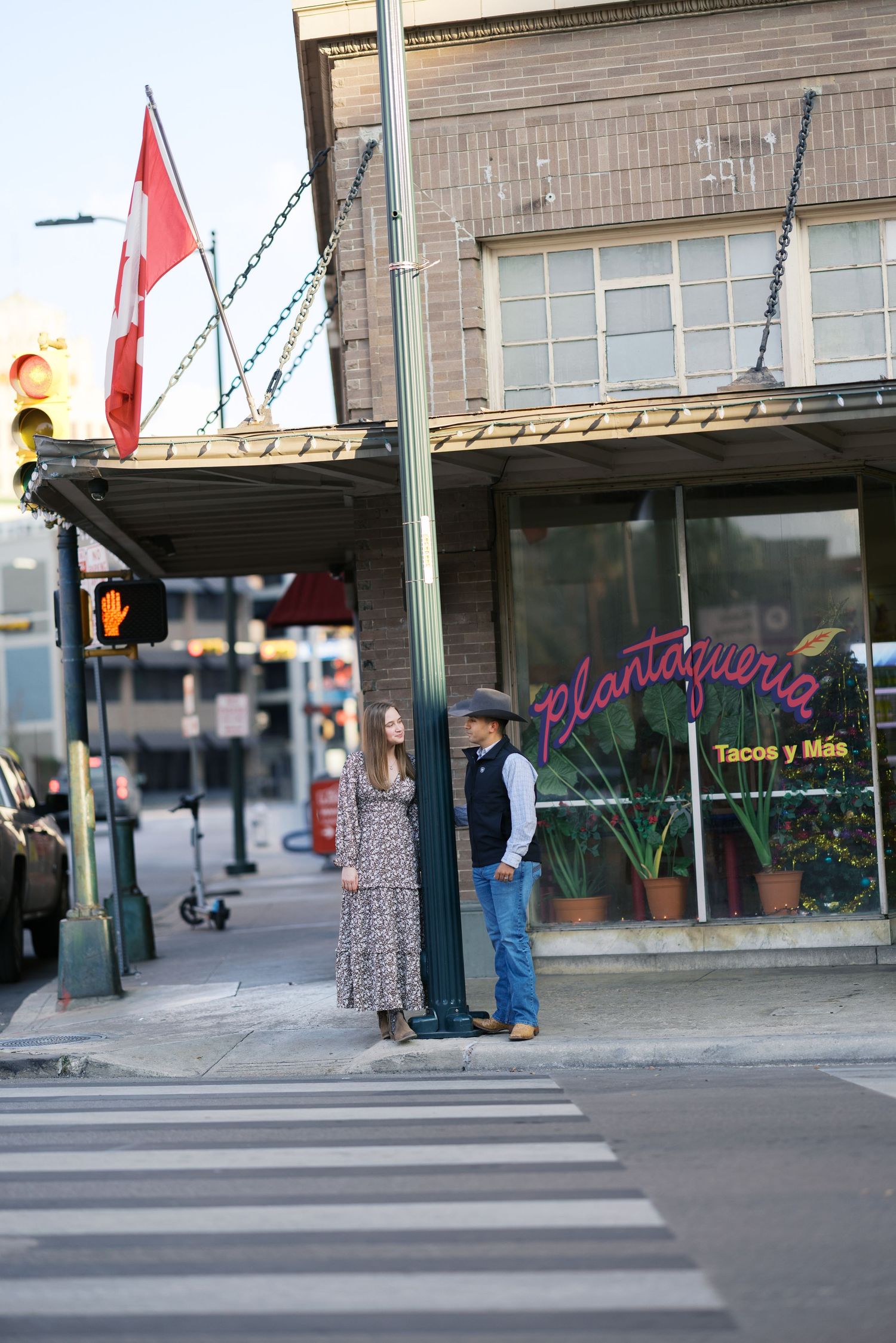 Urban street scene with storefronts and neon signs visible in the background.