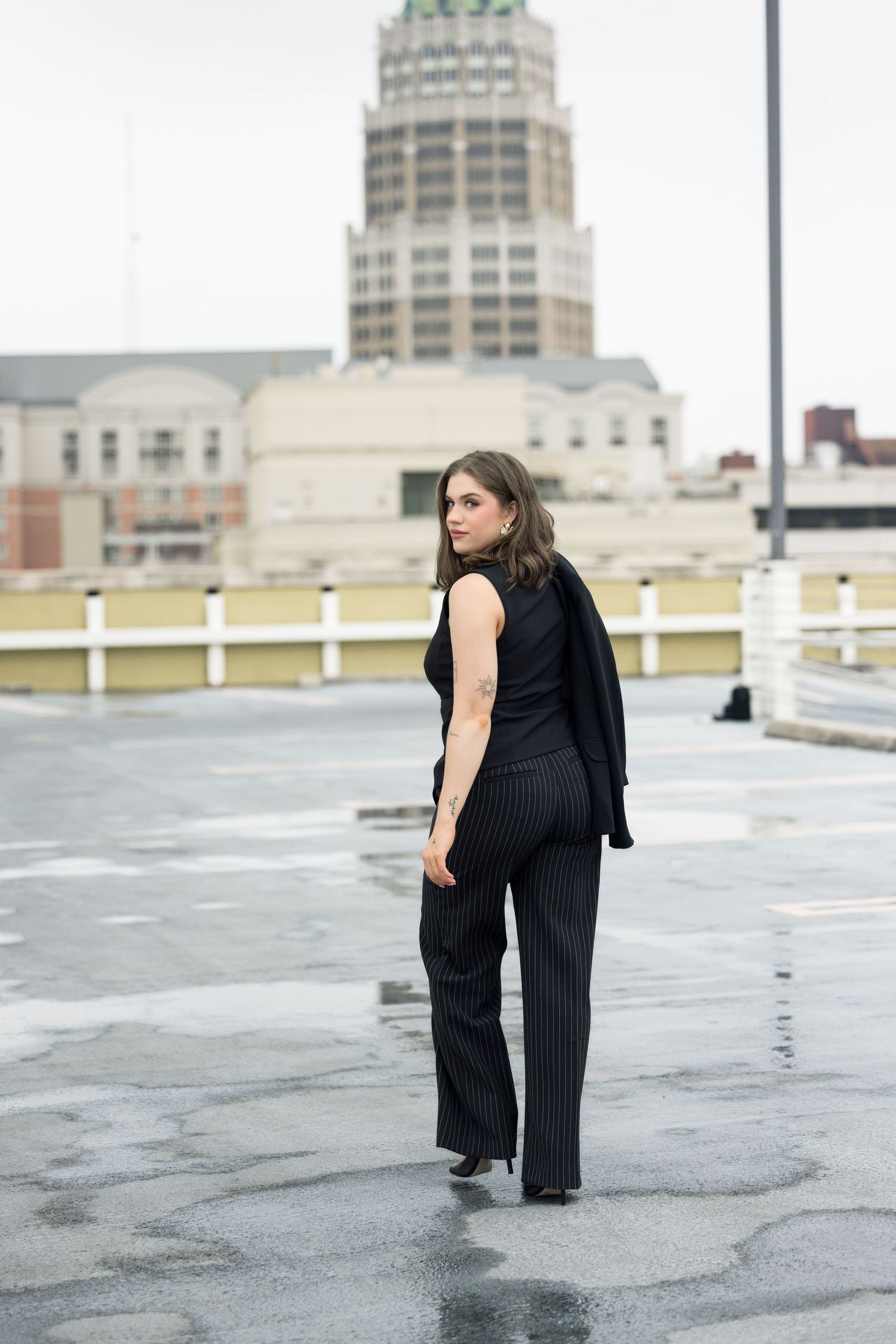 Artistic fashion photography sequence on urban rooftop with architectural backdrop.
