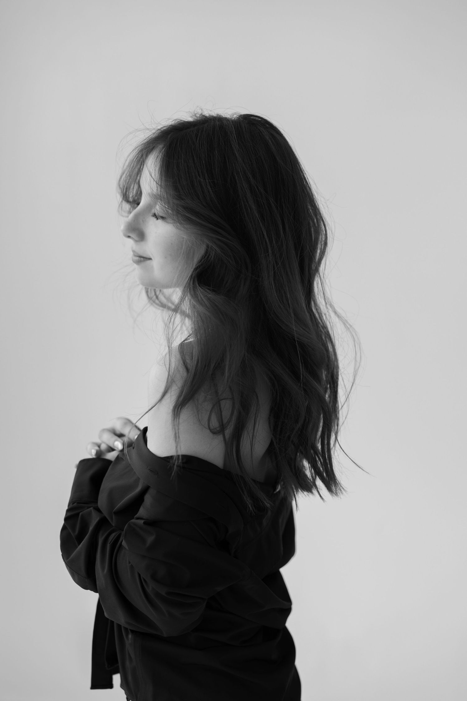 Artistic black and white portrait series showing movement of hair against white background.