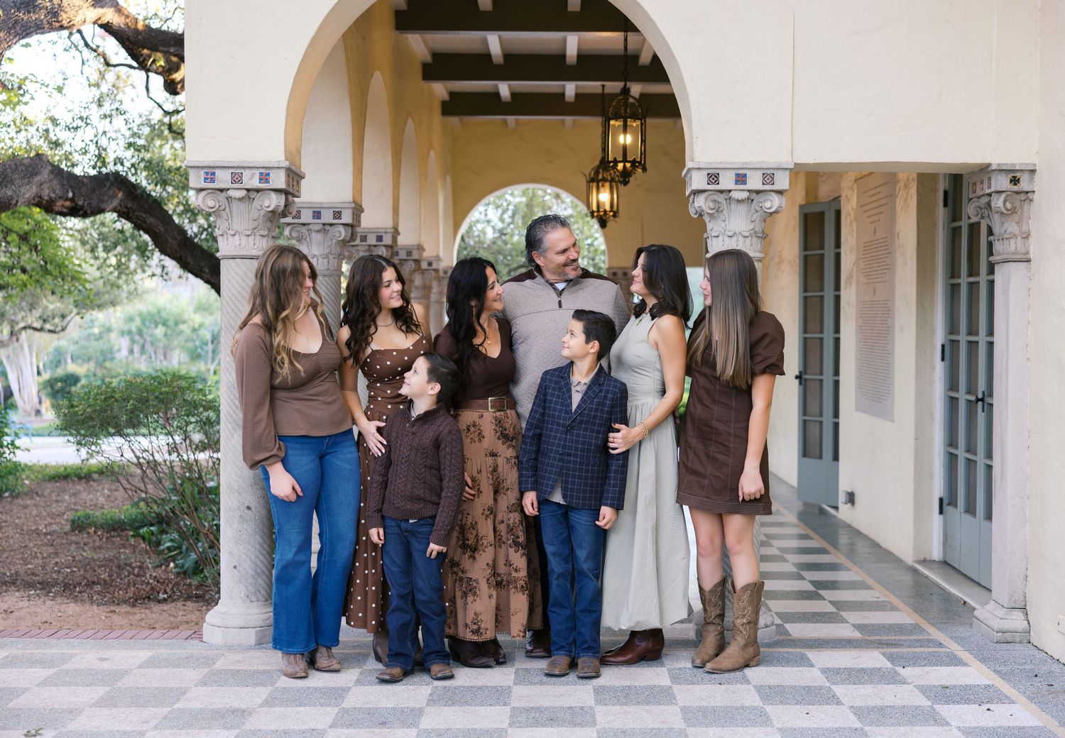 A group photo taken under an ornate archway of a Spanish colonial style building.