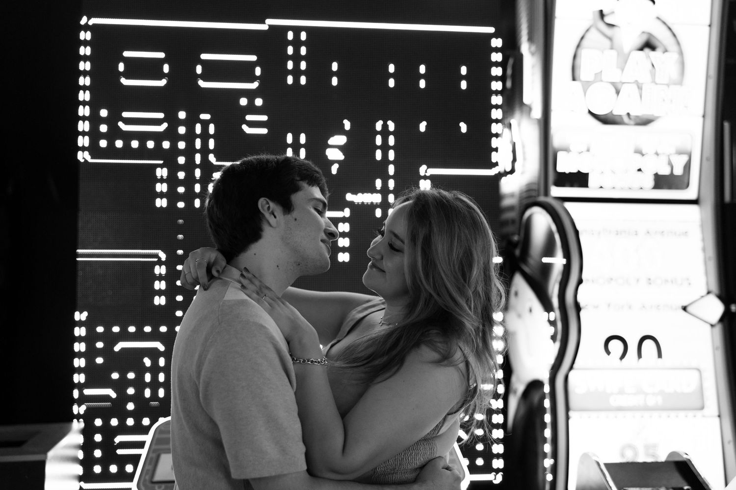 Black and white arcade scene with retro gaming graphics visible in background.