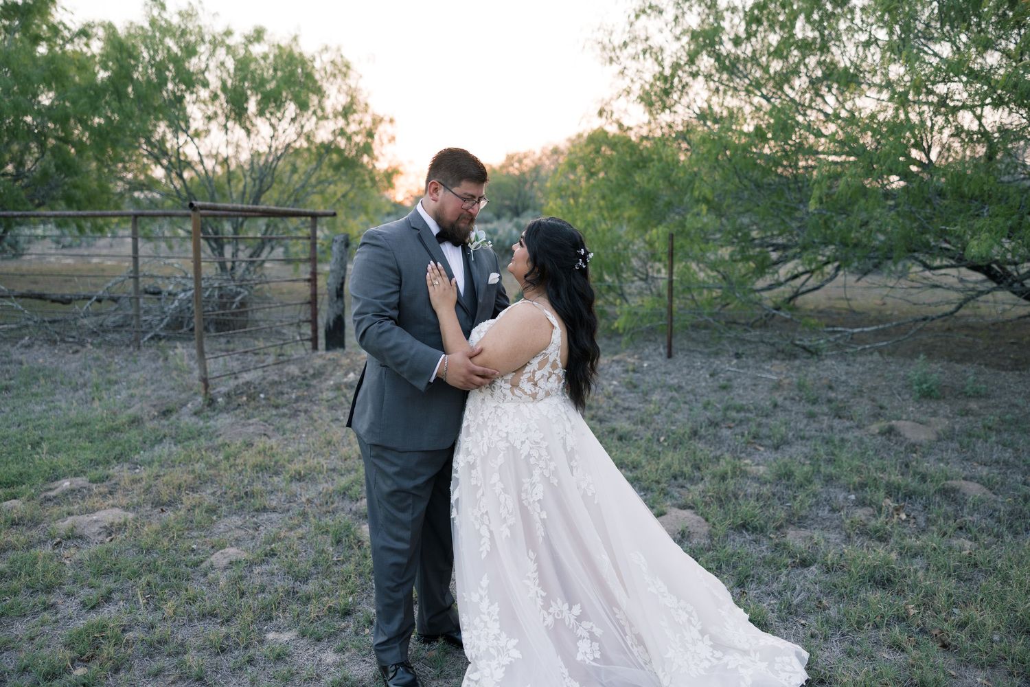 Romantic outdoor wedding portraits of couple in formal attire against natural landscape.