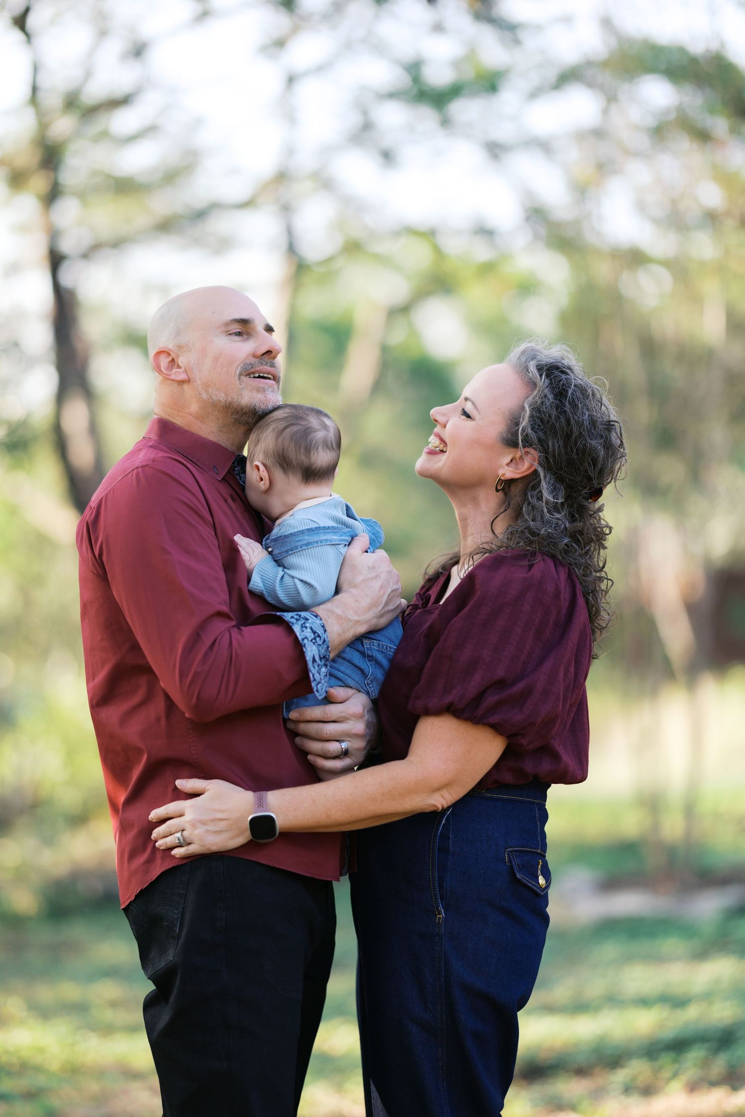 Candid family photos showing loving interactions outdoors in burgundy and navy outfits.