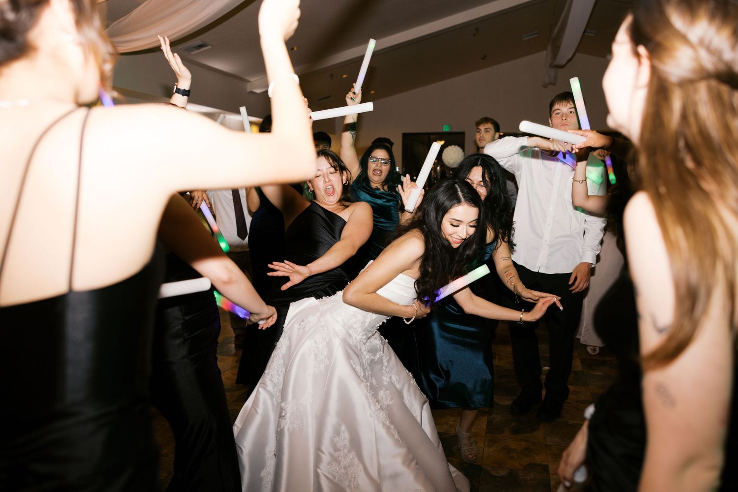 Wedding reception dance party with guests dancing in a circle around the bride.