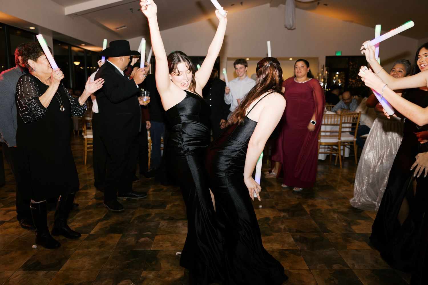 Crowd of people dancing with raised arms at a nighttime celebration.