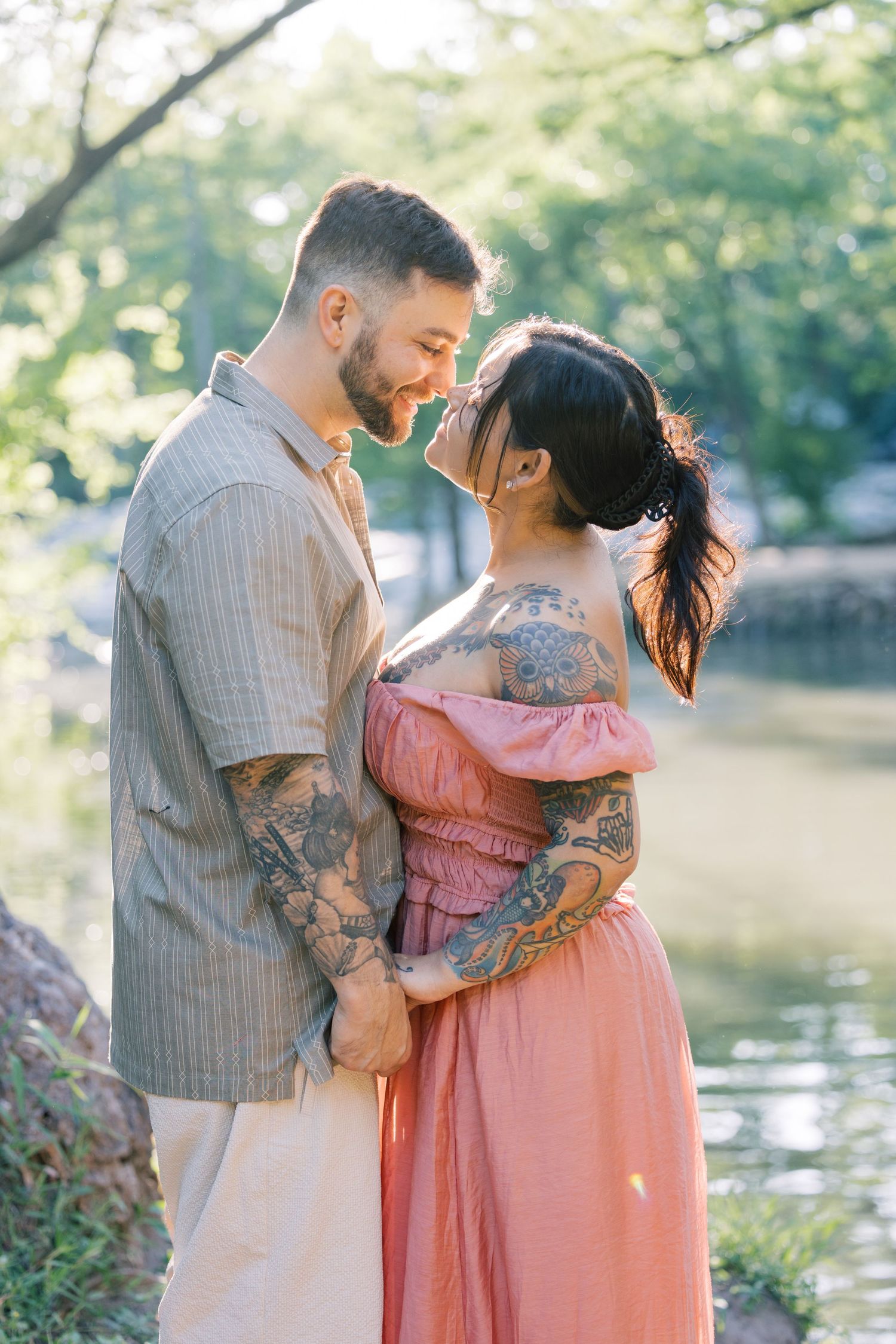 Tender moments between a couple wearing coordinated outfits during their lakeside photoshoot.