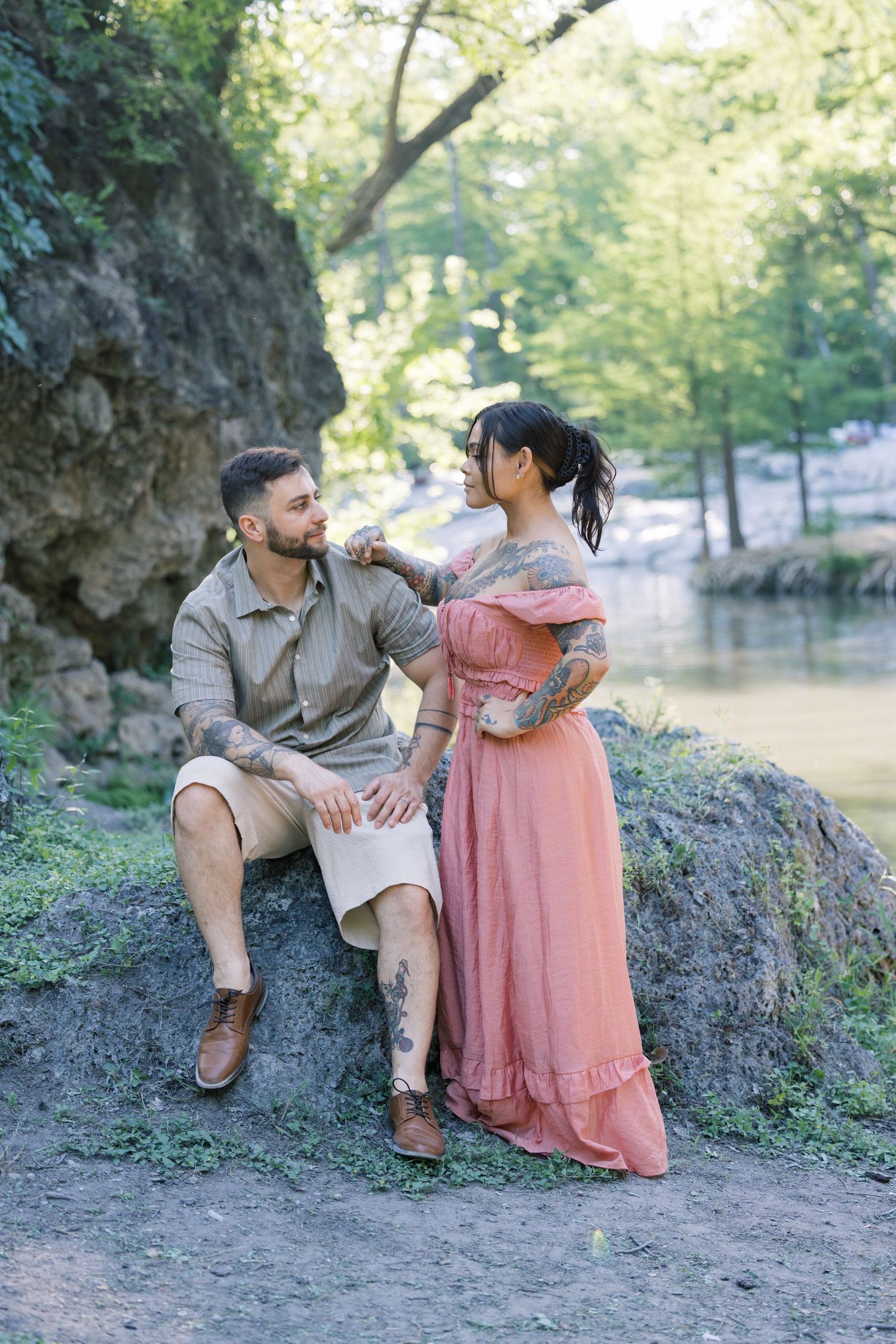 Outdoor photoshoot in a natural setting with rocks and trees.