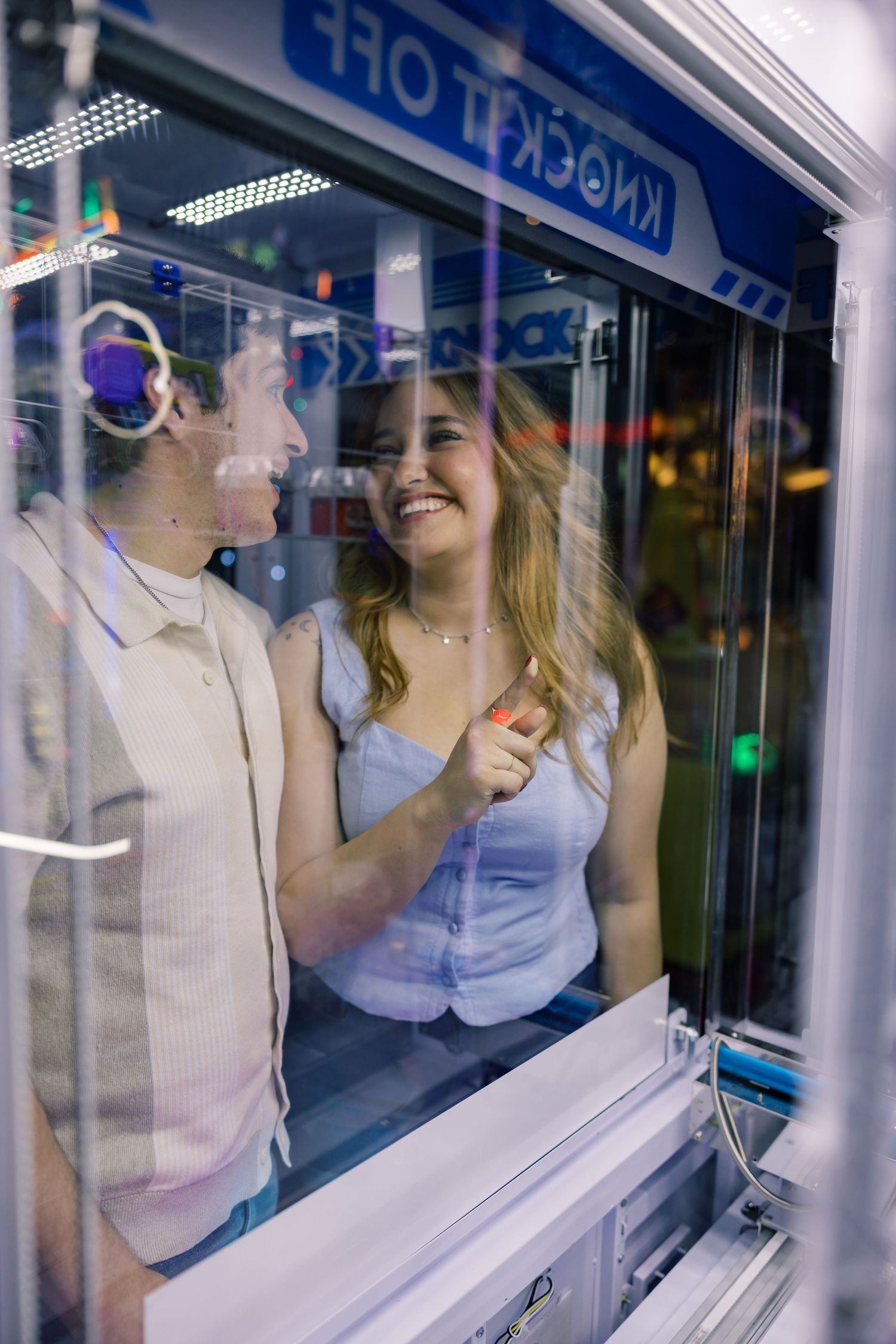 Reflective glass panels create mirror effect of people at an entertainment venue.