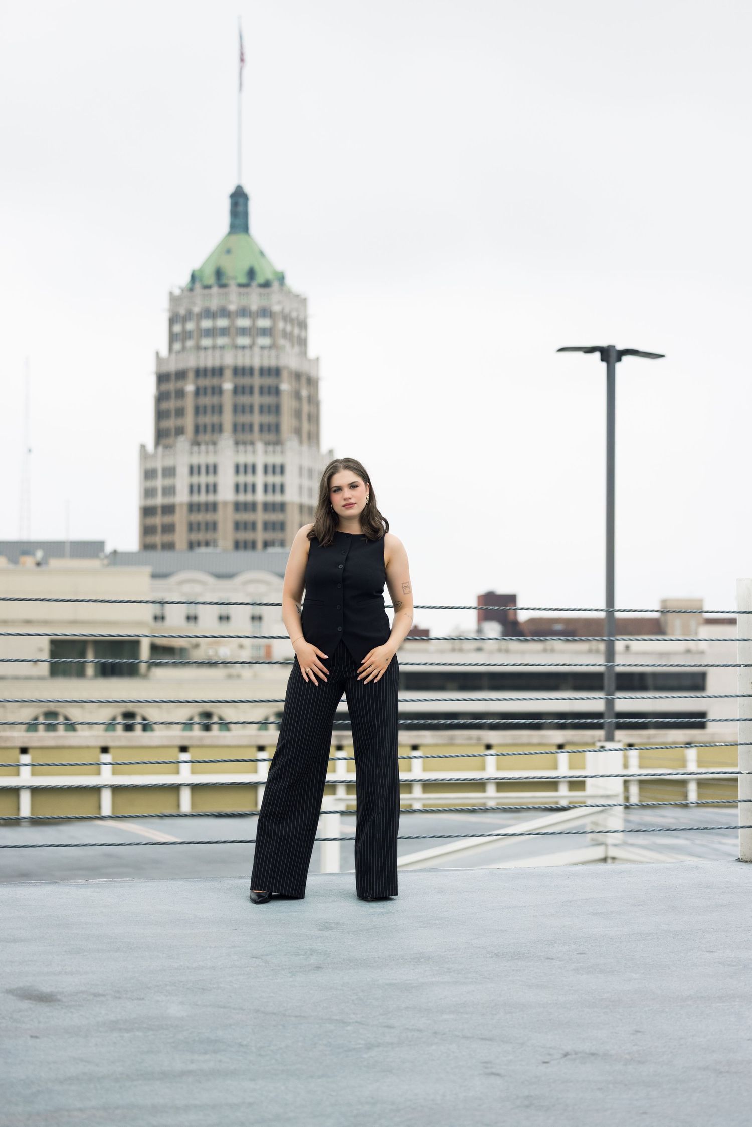 Modern fashion shoot on parking deck with Art Deco architecture in the background.