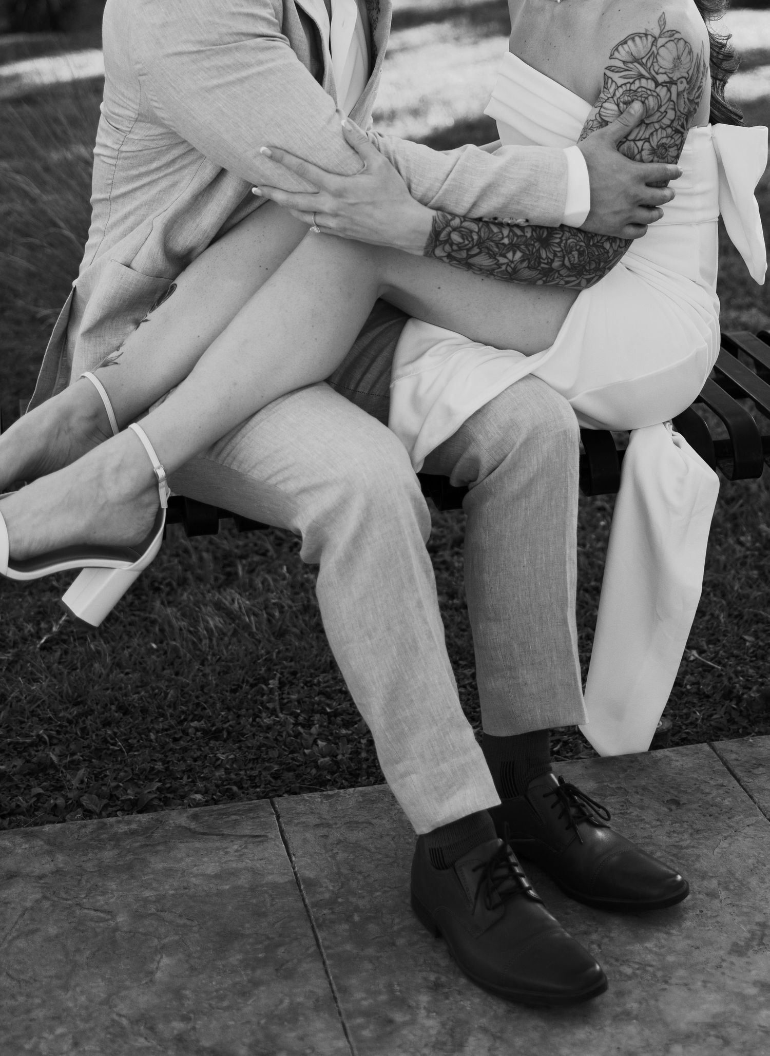 Black and white series showing legs and feet of couple sitting close together.