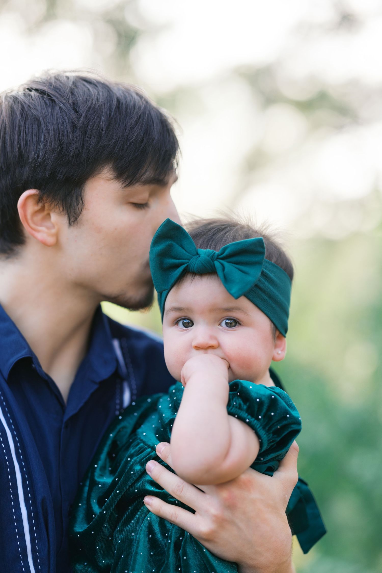 Close-up outdoor photo session showing affectionate family moments.