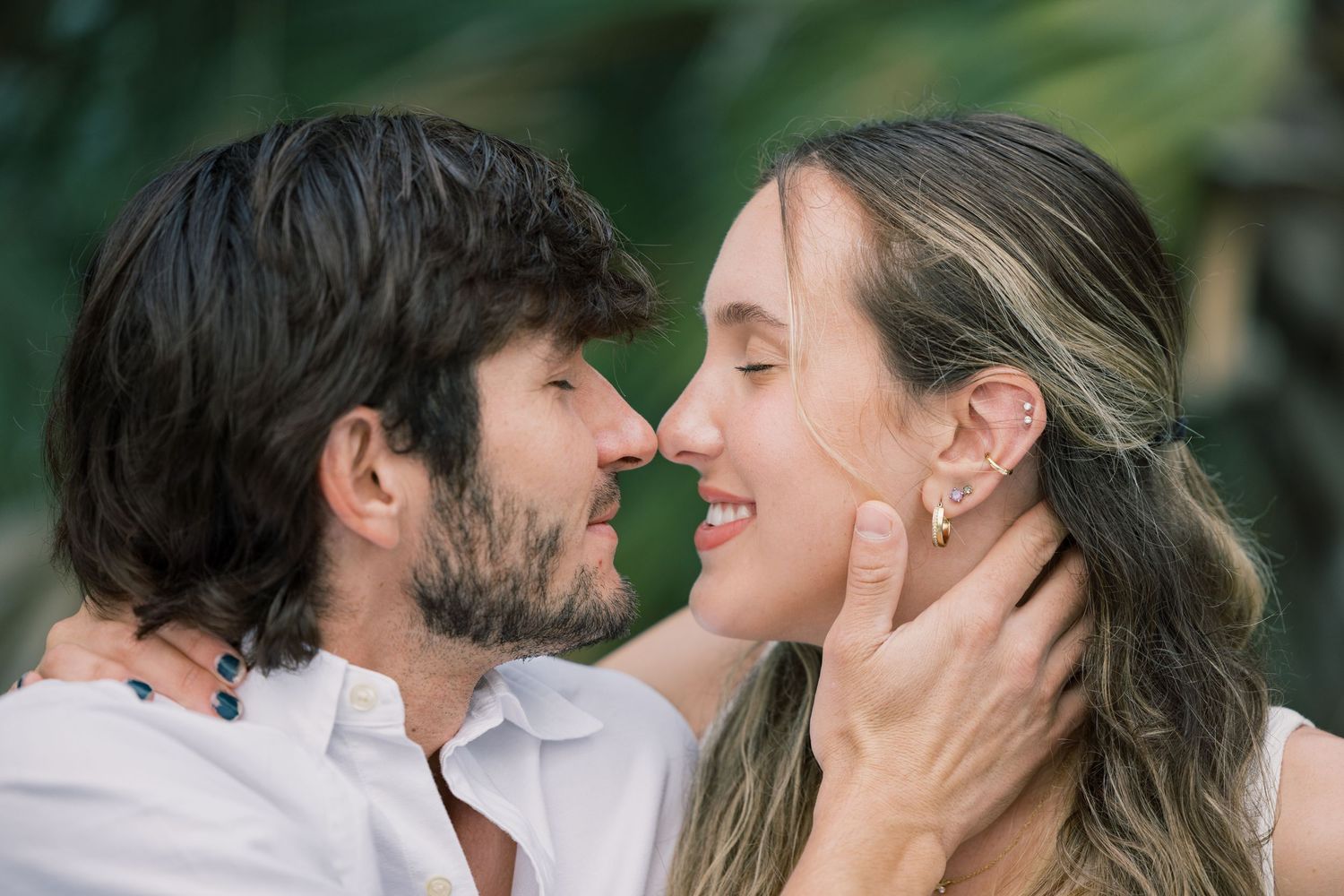 An intimate close-up of a couple sharing tender moments in a natural outdoor setting.