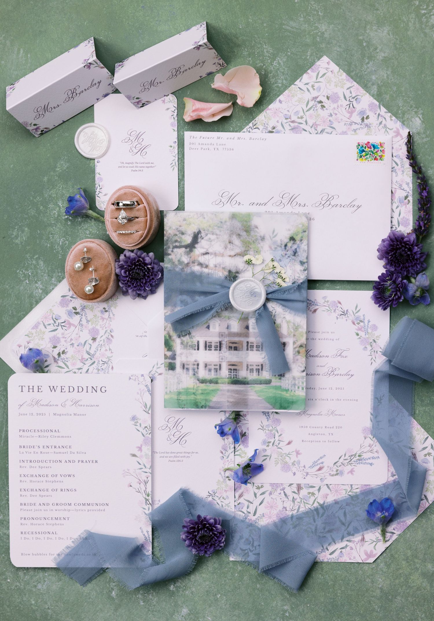 Elegant wedding invitation suite with blue floral details, ribbons, and a watercolor venue illustration.