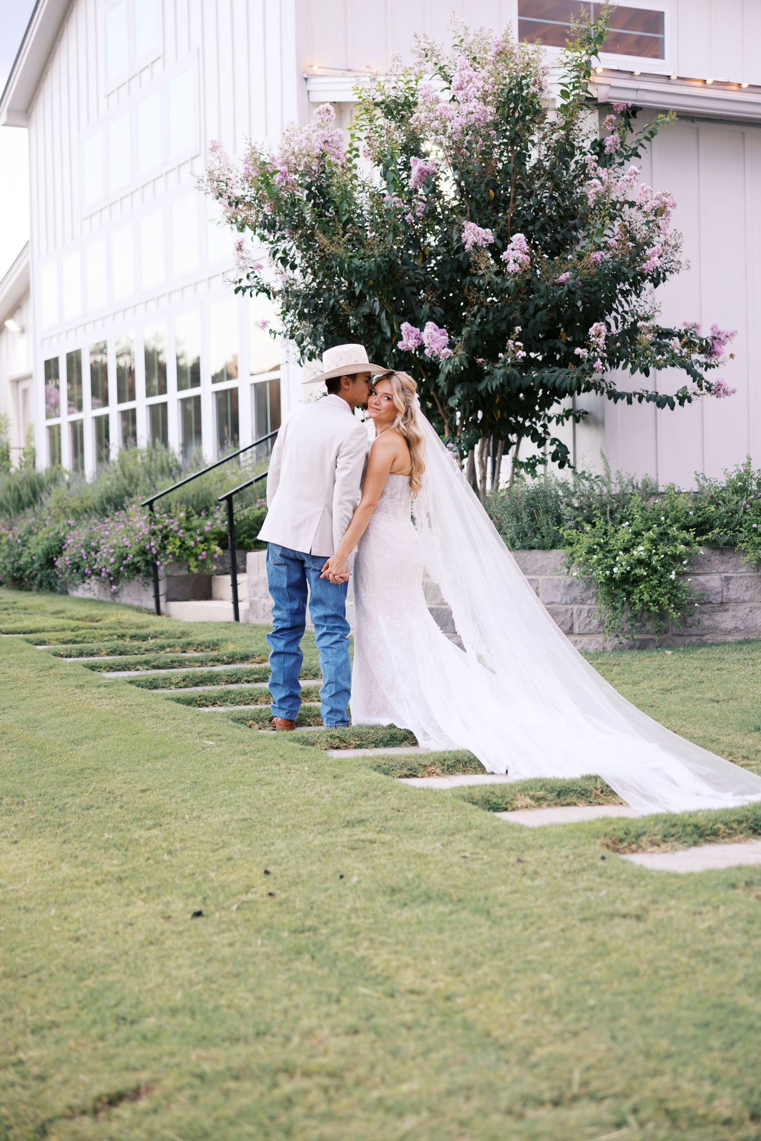 A romantic wedding photoshoot sequence showing a couple dancing on a grassy lawn near a white building.