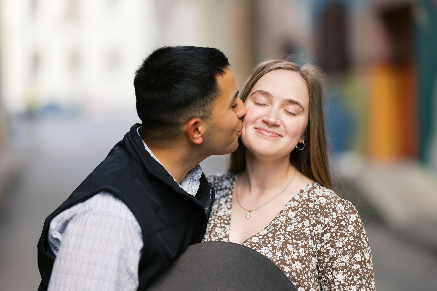 A tender moment captured between a couple during an outdoor engagement photoshoot.
