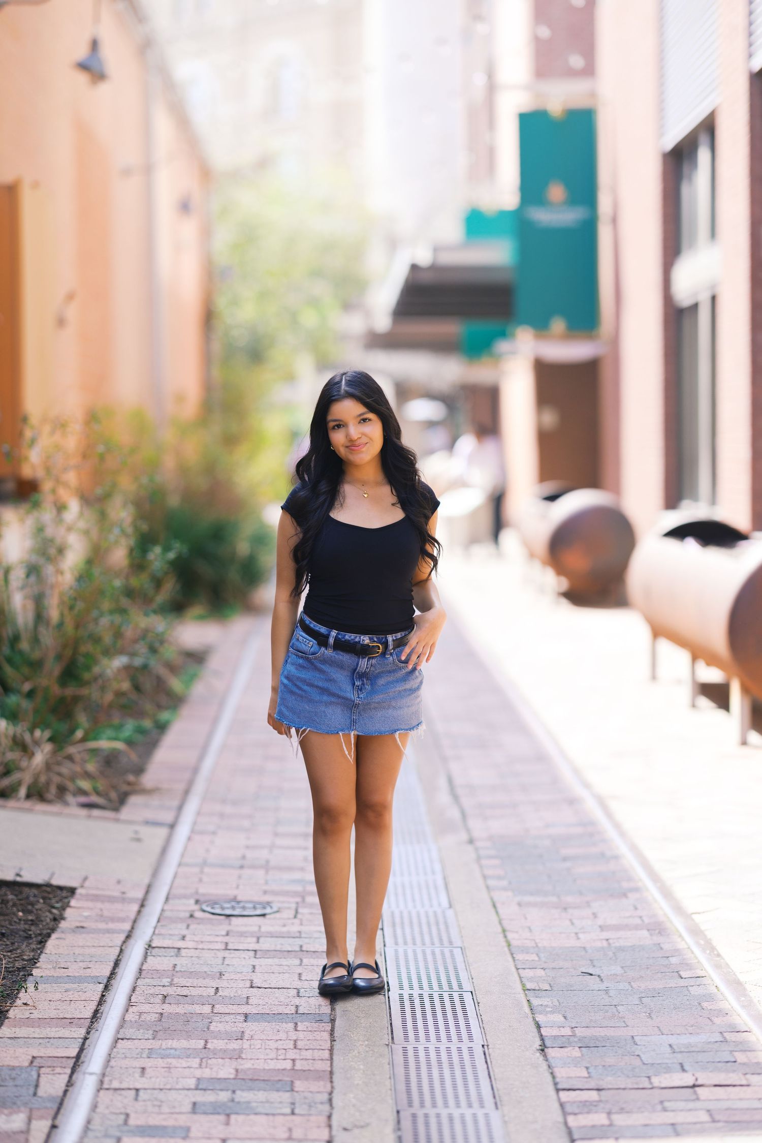 Fashion portraits taken on a brick pathway with decorative planters and teal shutters.