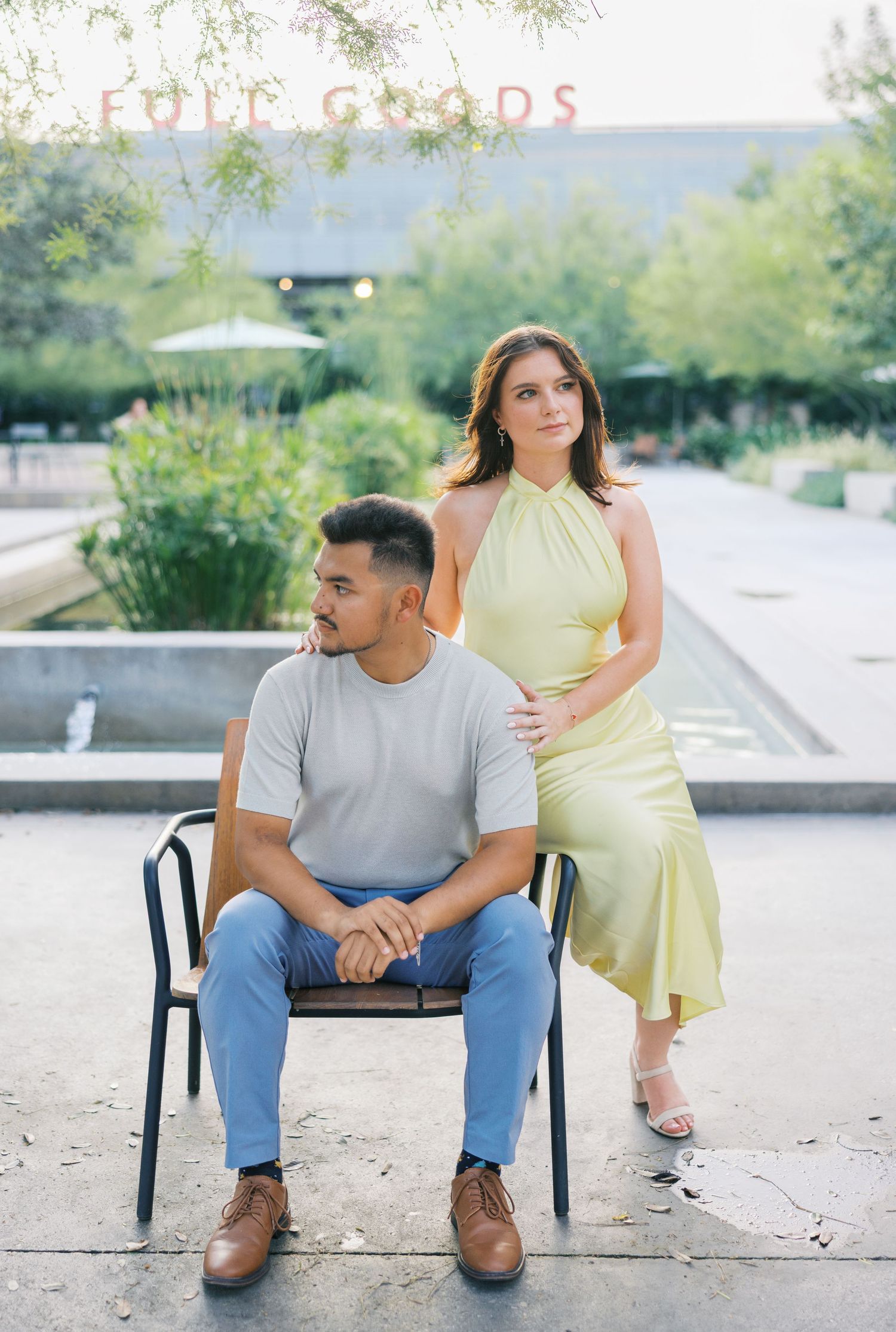Couple sitting on outdoor chairs with scenic background.