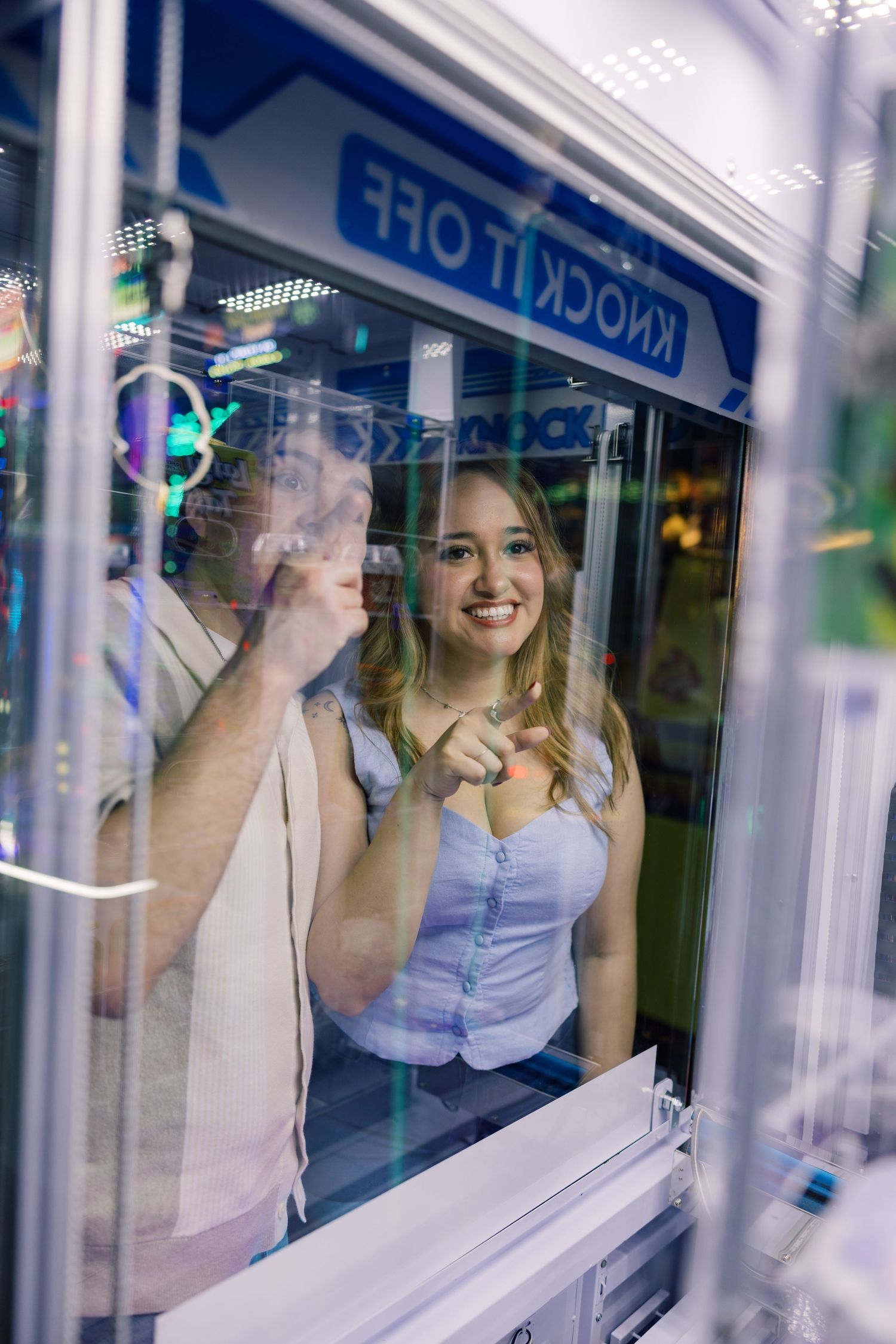 Repeated reflections in window panes showing people at an arcade.