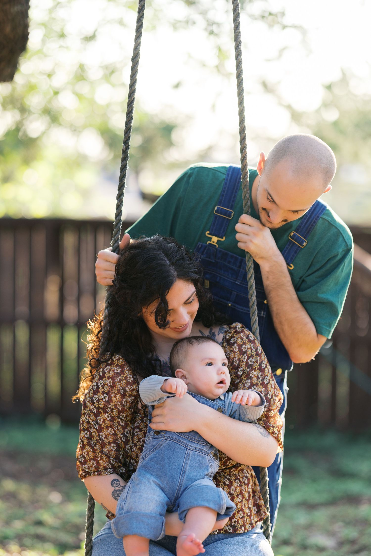 Playful family moment captured on outdoor swings during a photo session.