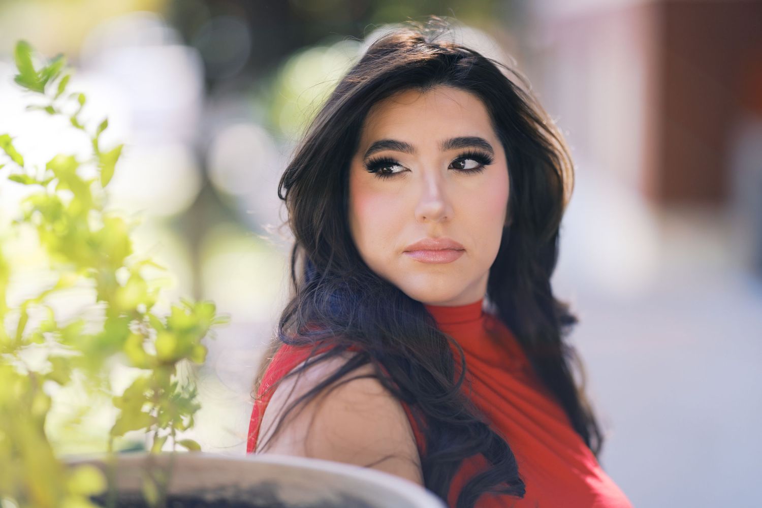 An artistic portrait with soft lighting highlighting a red turtleneck outfit.