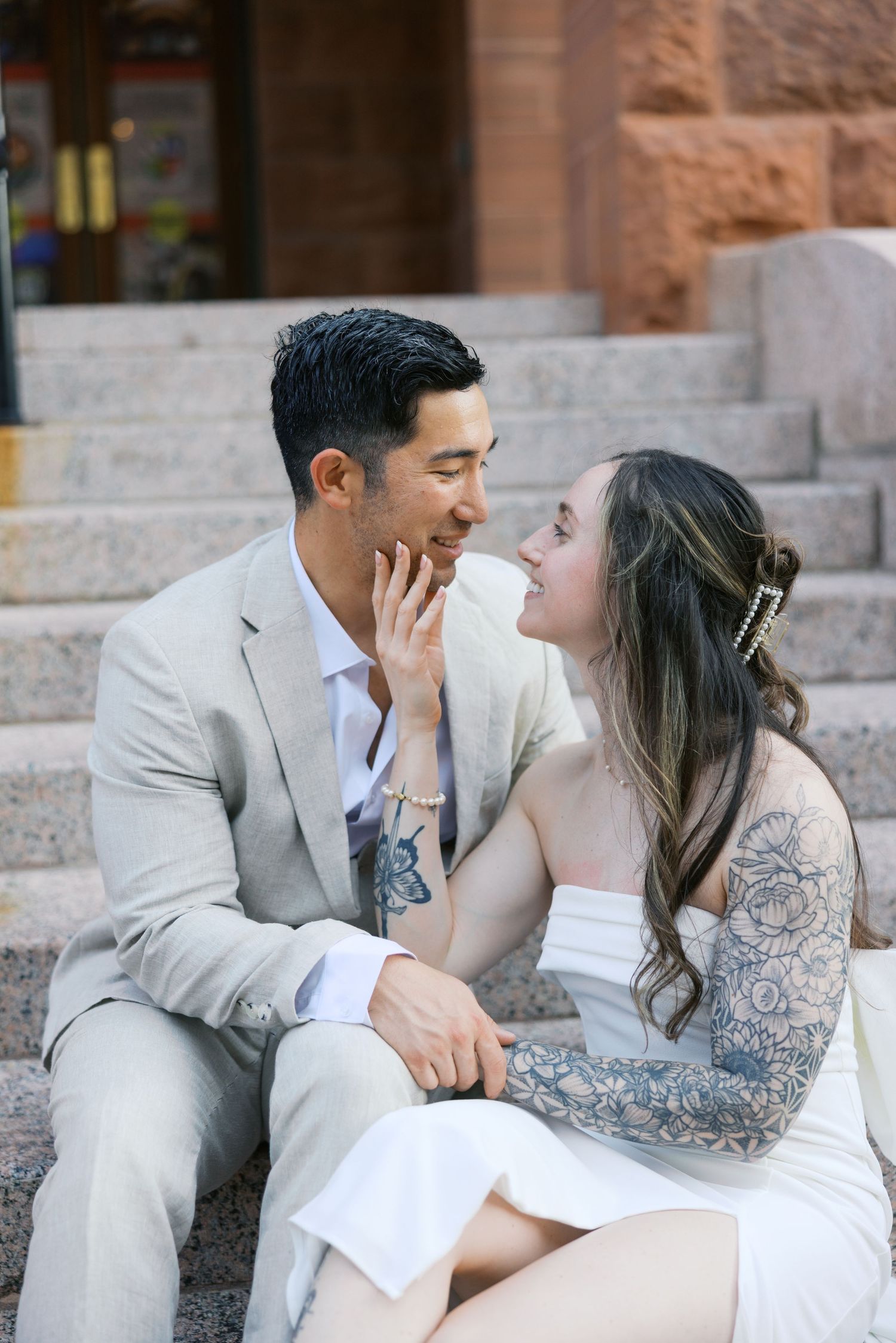 Intimate engagement photo session on stone steps of historic building.