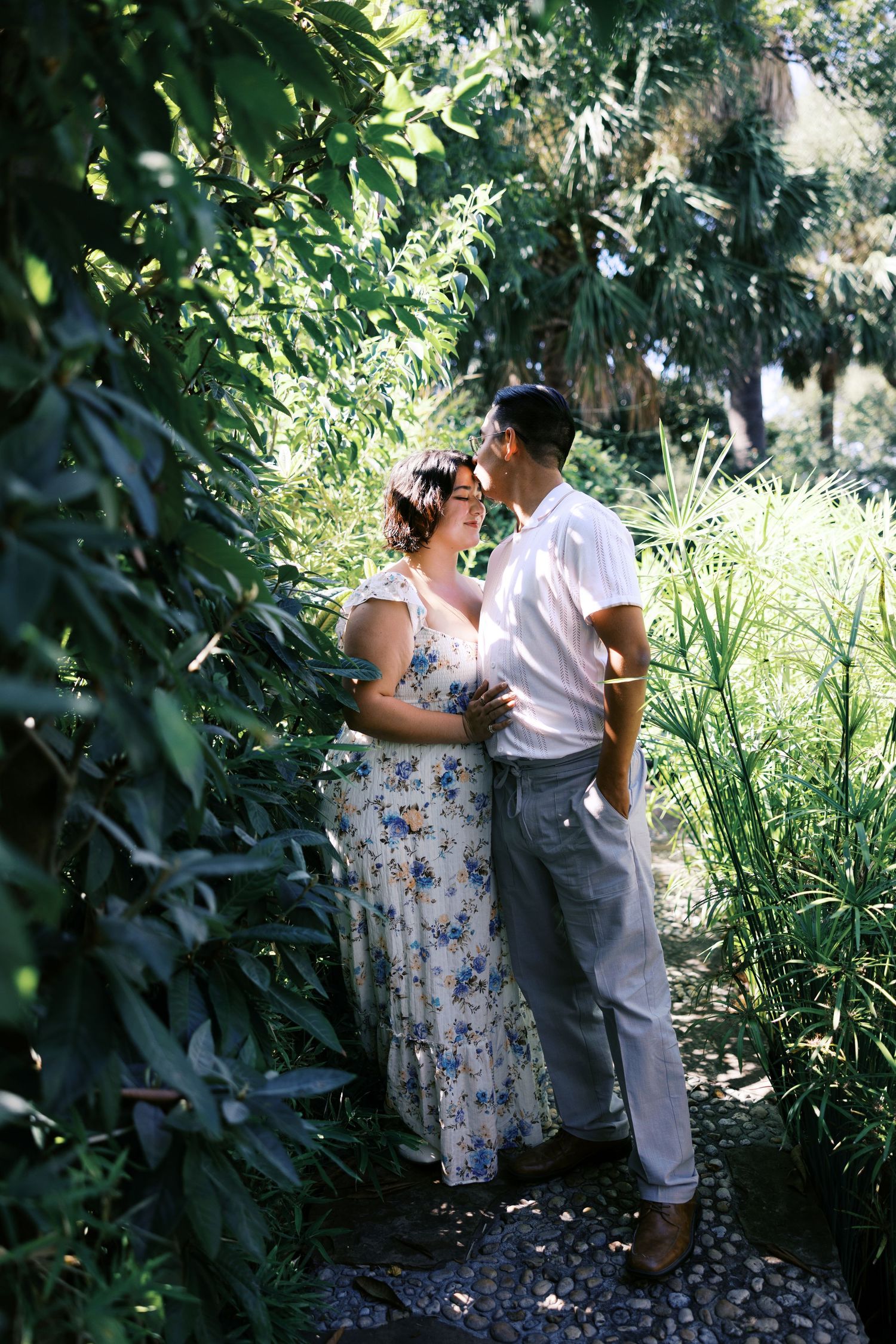 An intimate garden portrait with natural sunlight filtering through dense foliage.