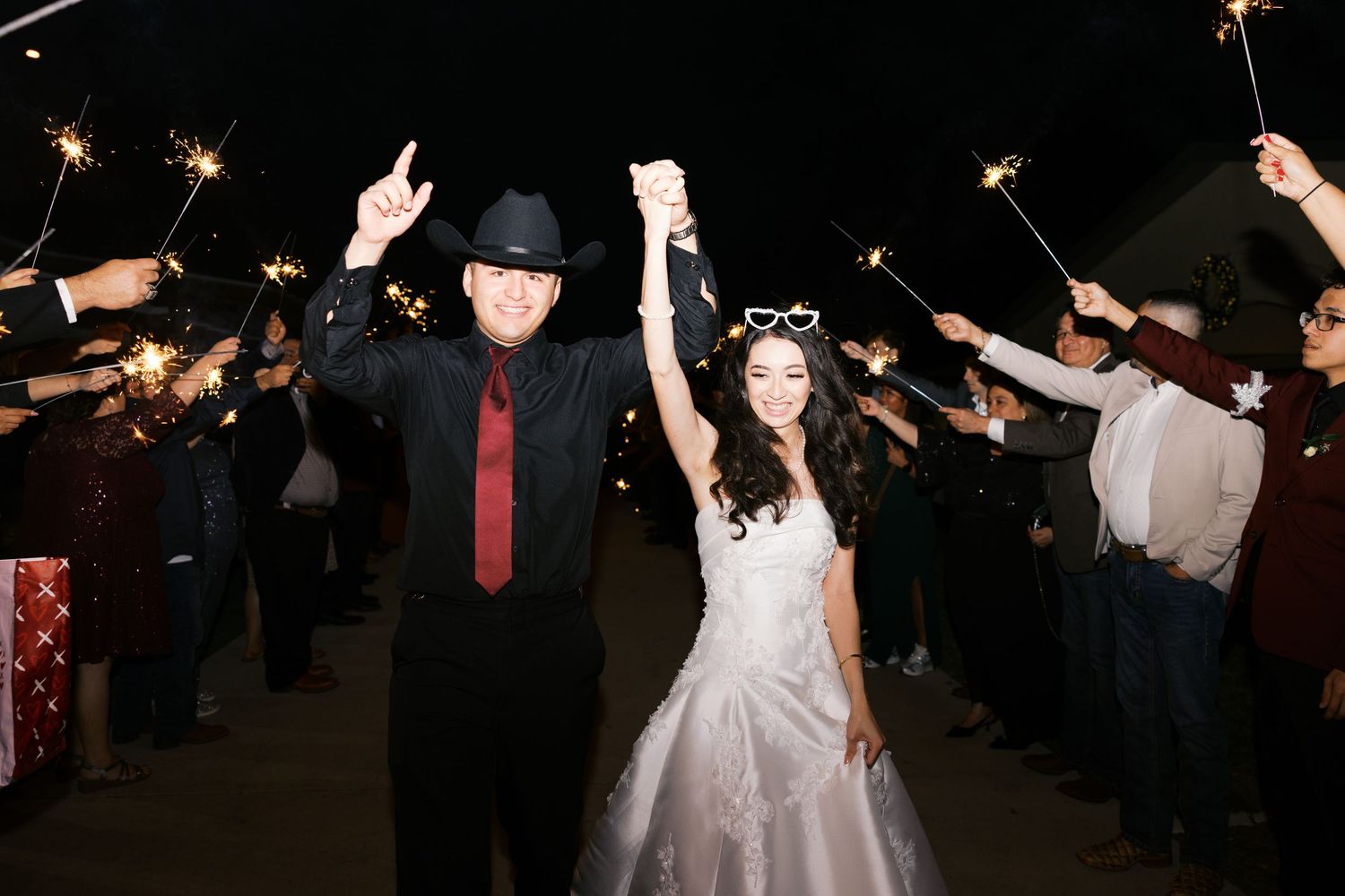 Wedding sparkler exit with guests holding lit sparklers as couple walks through.