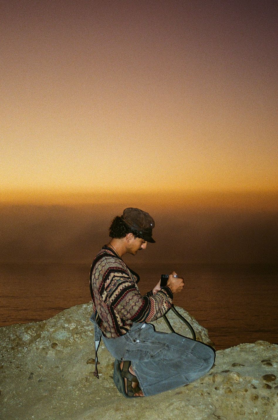 film photo during sunset of man posing with camera in san diego california