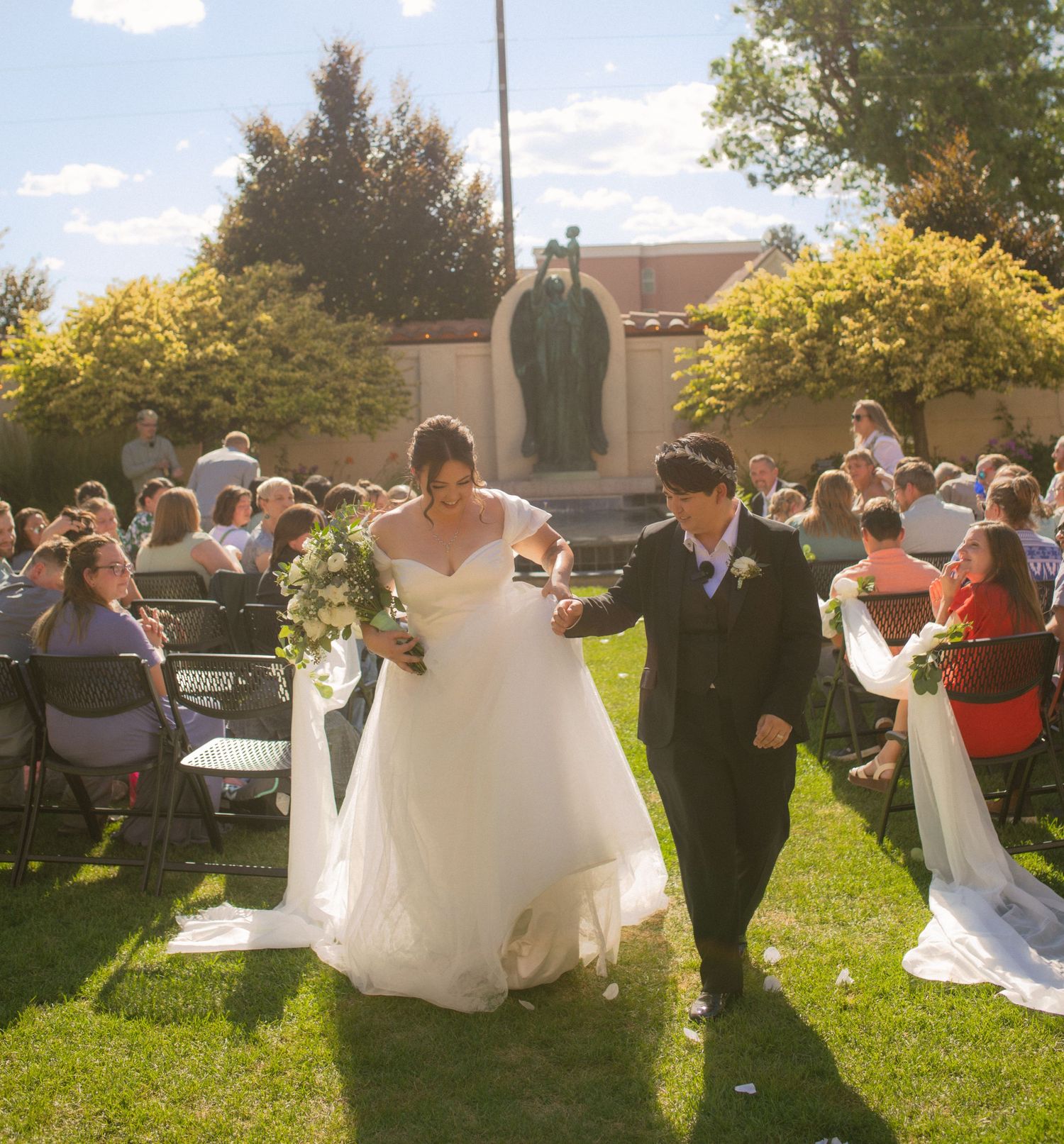 two women walking down the aisle moments after their wedding ceremony in utah