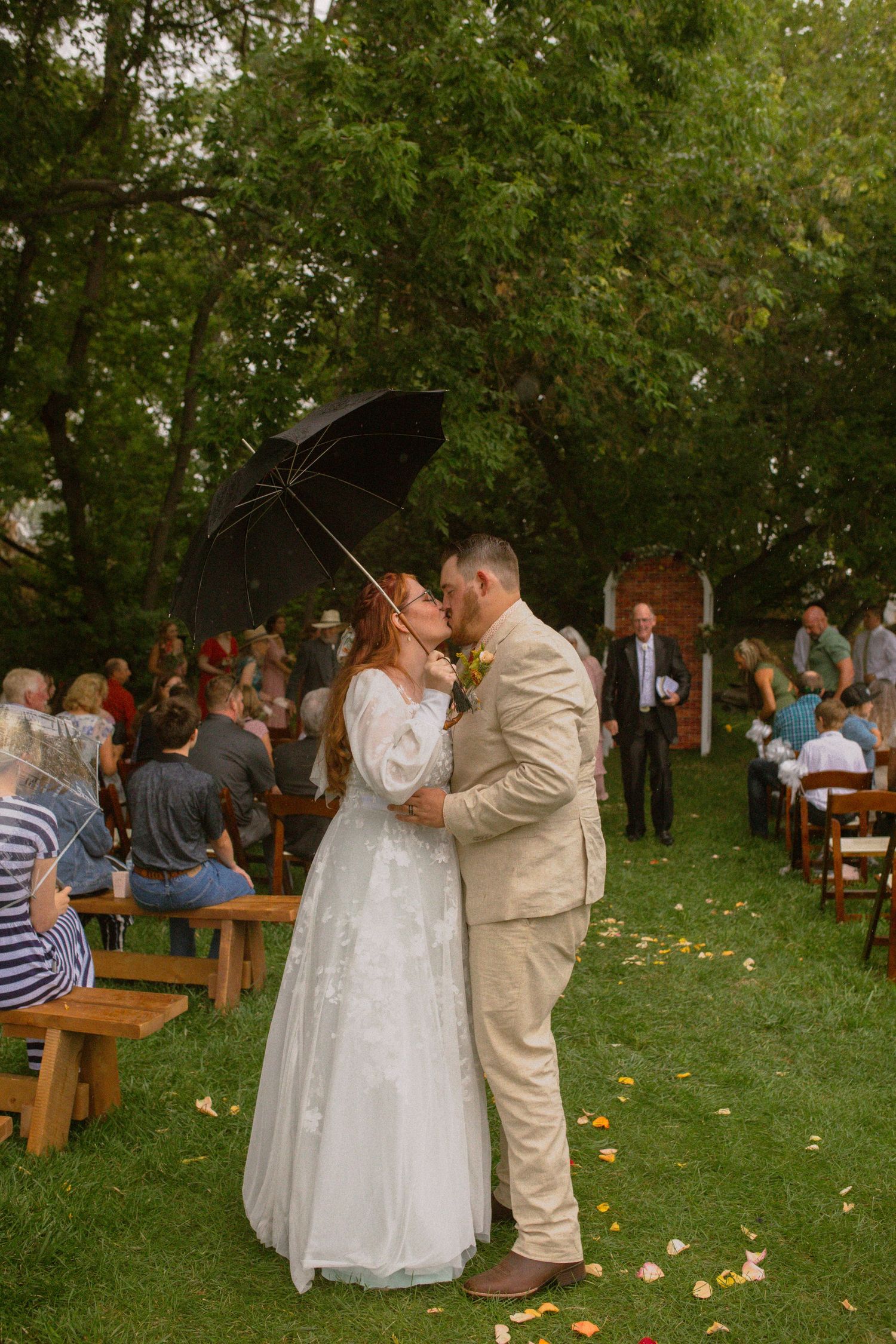 couple kisses in rain moments after their ceremony in wyoming