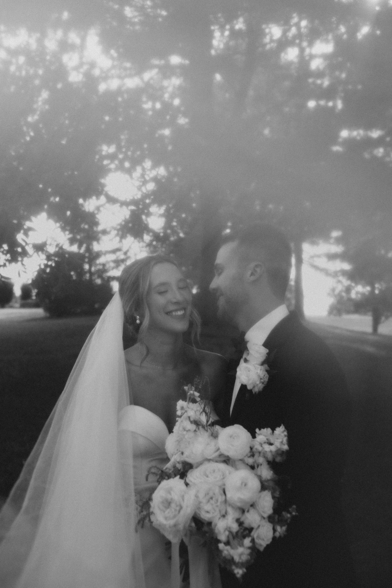 black and white photo of couple smilies during wedding day