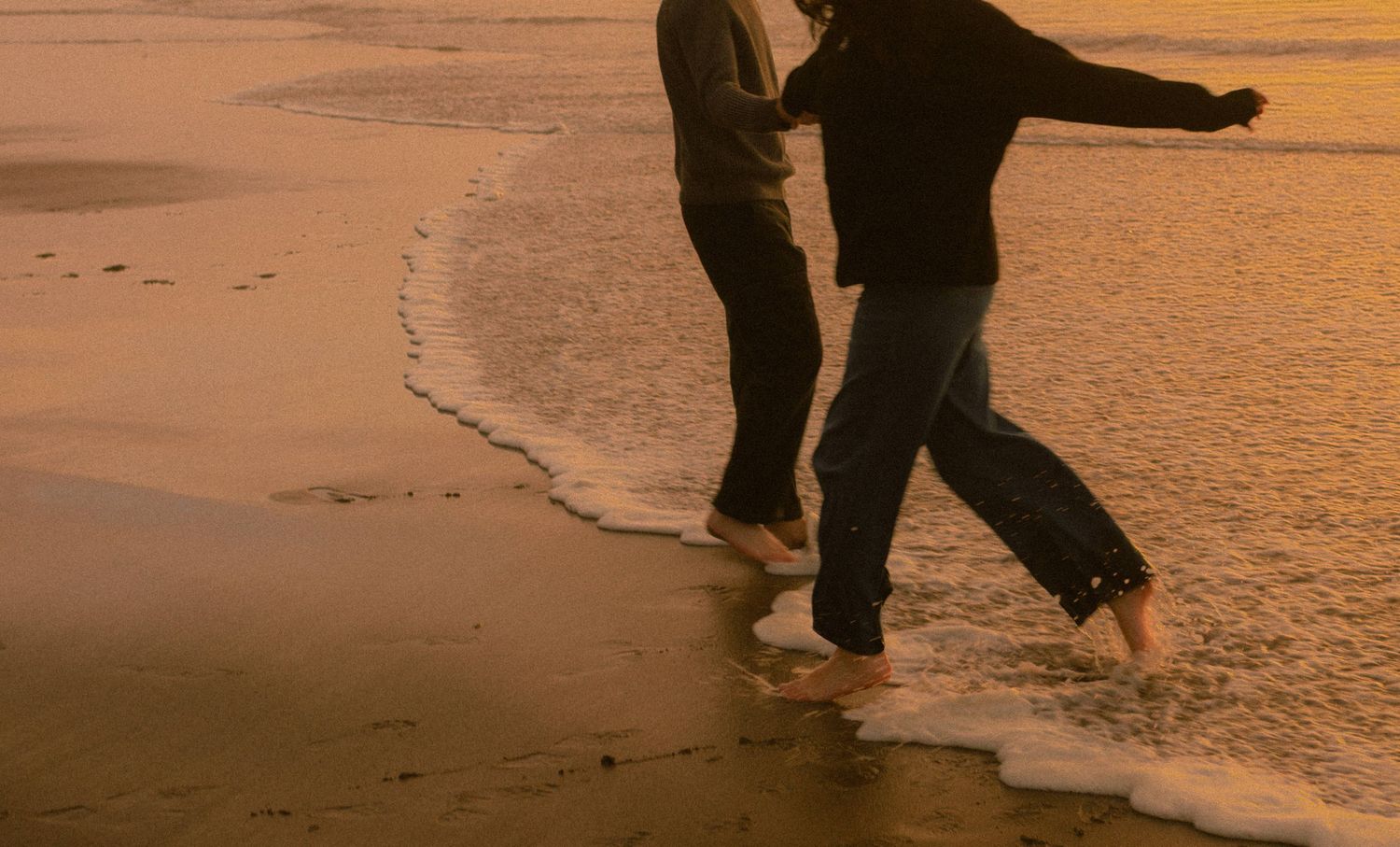 couple explores on oregon coast during sunset in lincoln city.
