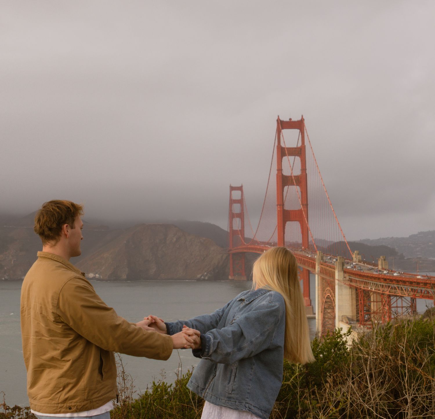 couple look back at golden gate bridge in california