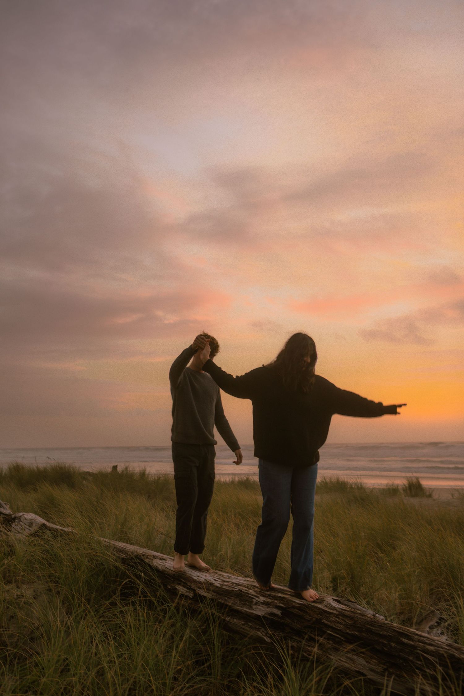couple explores on oregon coast during sunset in lincoln city.