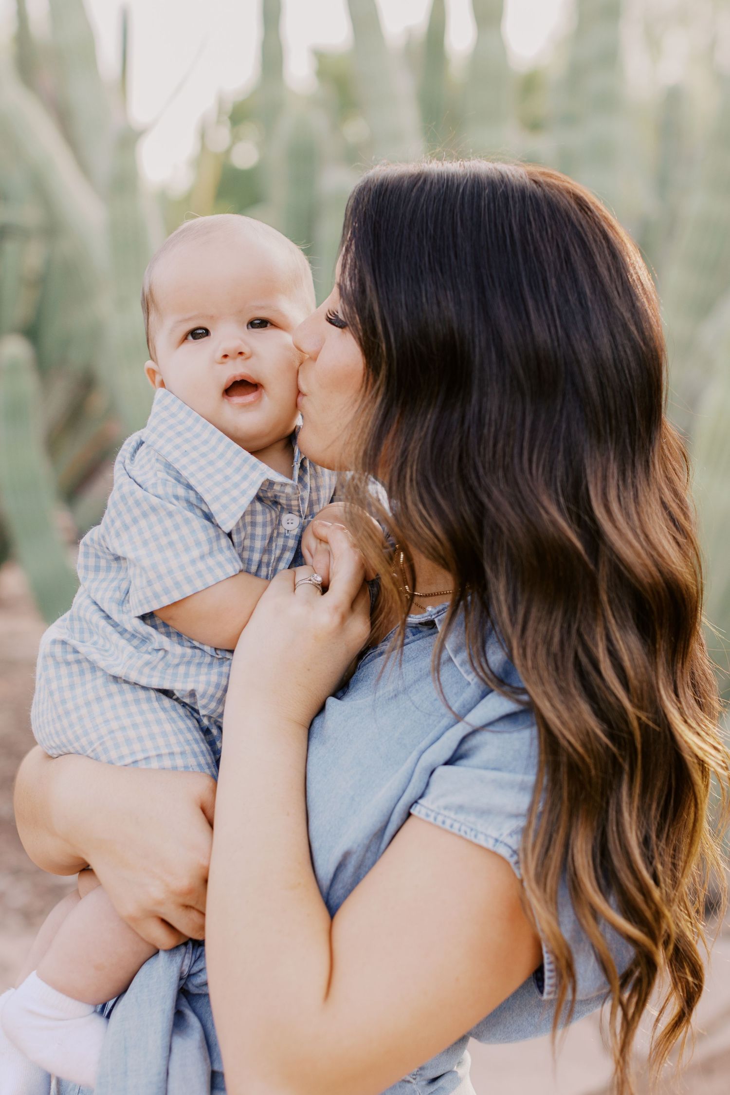 Tender moments between parent and baby photographed in a natural outdoor setting.