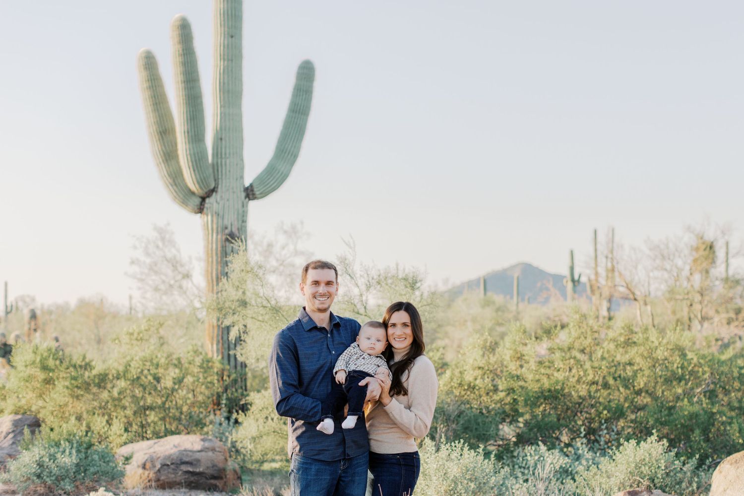 Desert landscape family photoshoot featuring saguaro cacti and natural lighting.