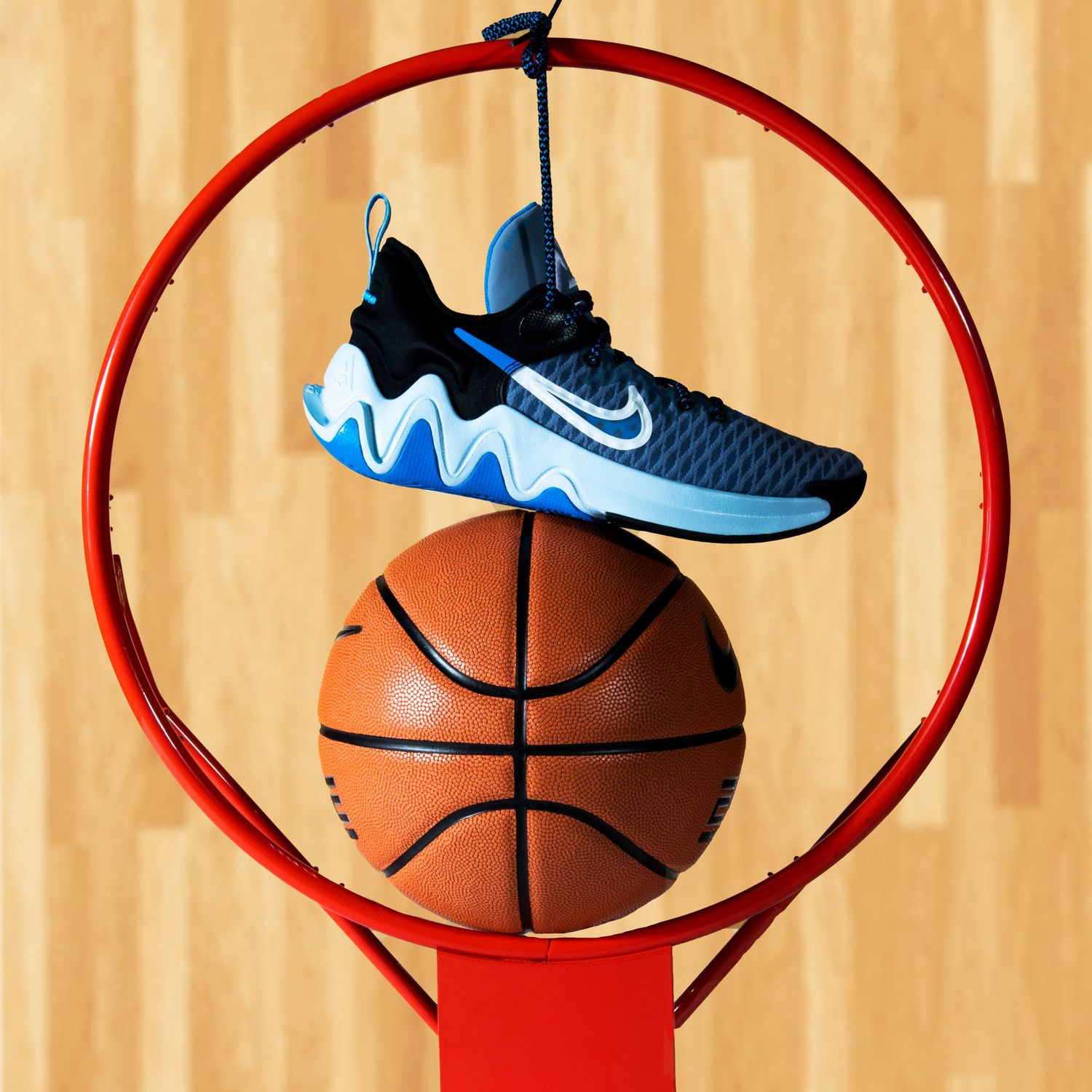 Basketball and athletic shoes hovering over court with red hoop rim sequence.
