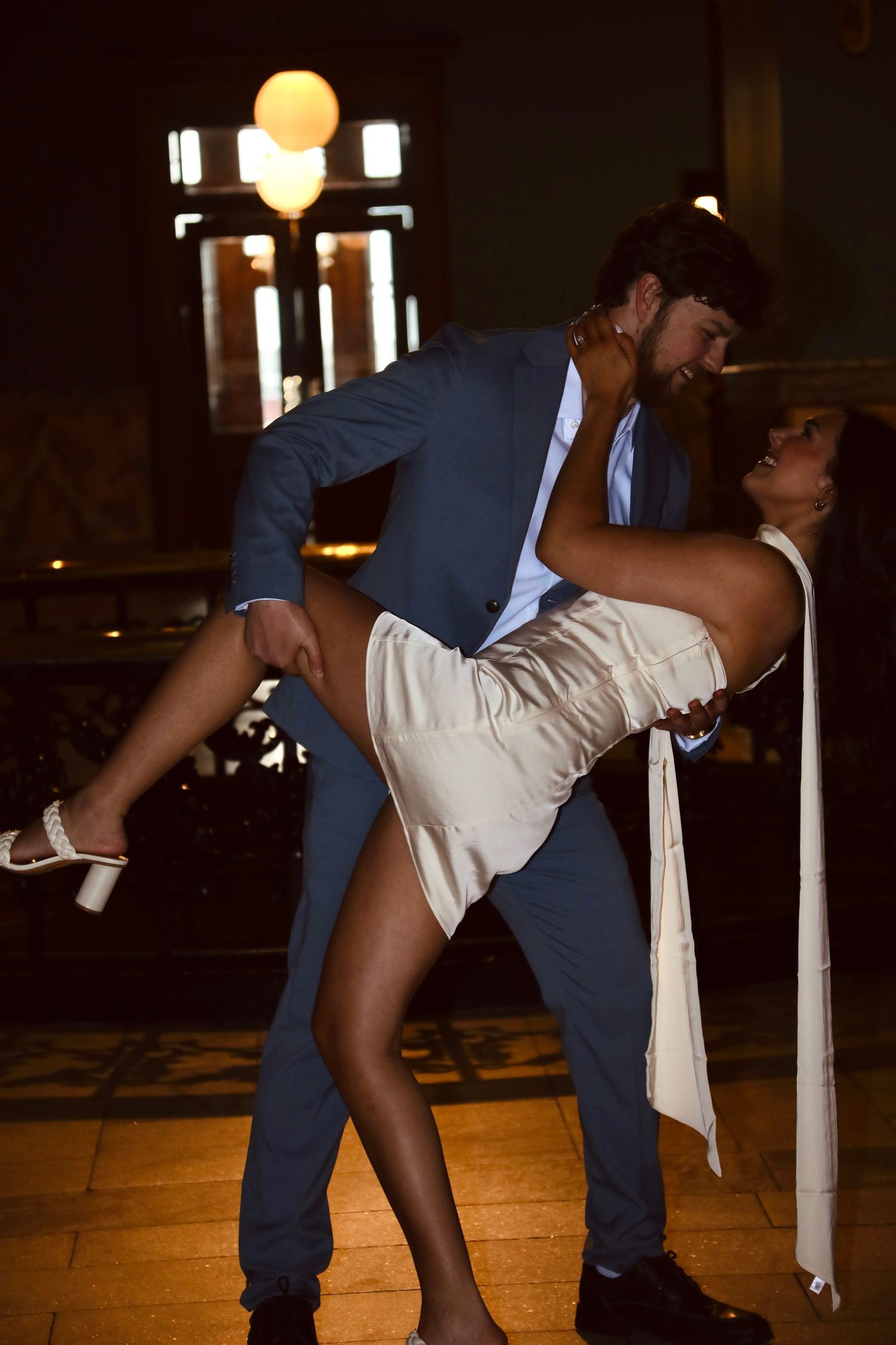 Couple performing a dramatic dance dip move on a dance floor.