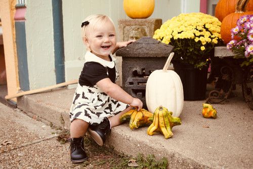Halloween decorations with pumpkins and mums on concrete steps.