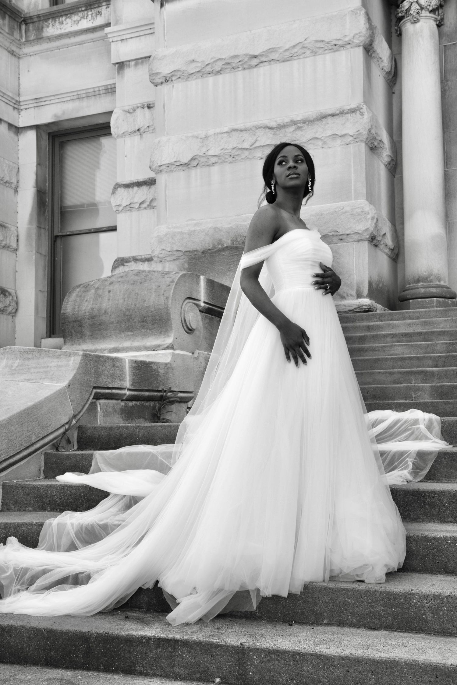 A series of black and white photos showing a bride in a flowing white dress posing gracefully on stone steps.