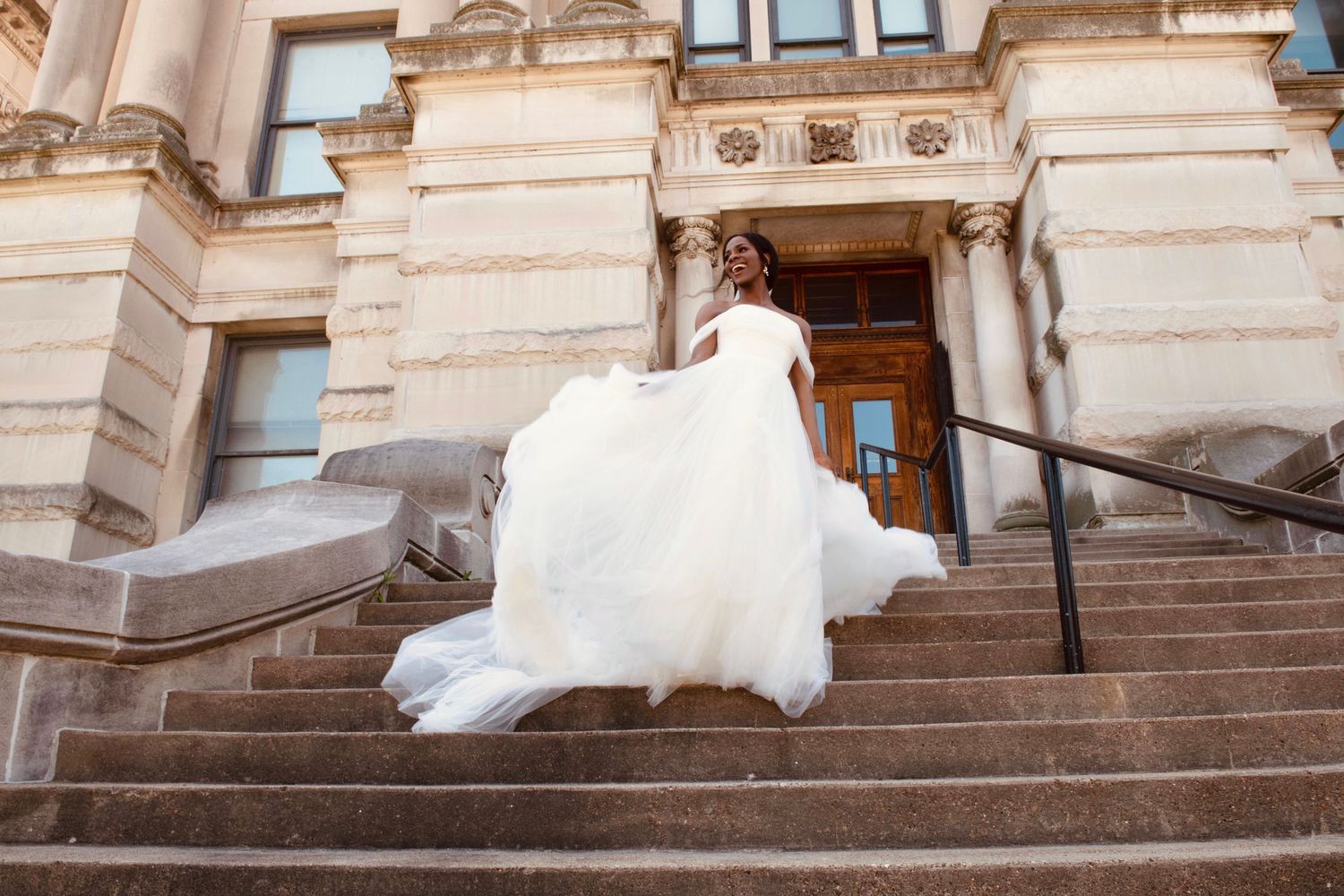 Wedding gown movement captured on historic building steps.