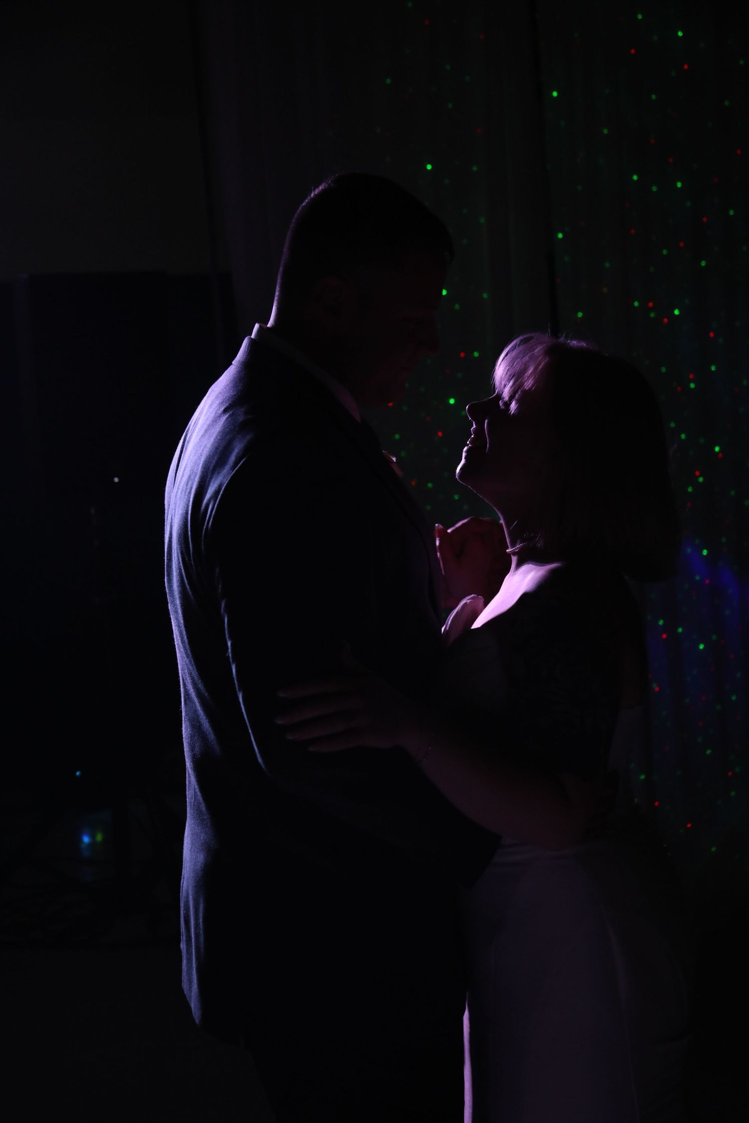 Silhouetted couple sharing intimate moment with purple lighting and sparkle effects.