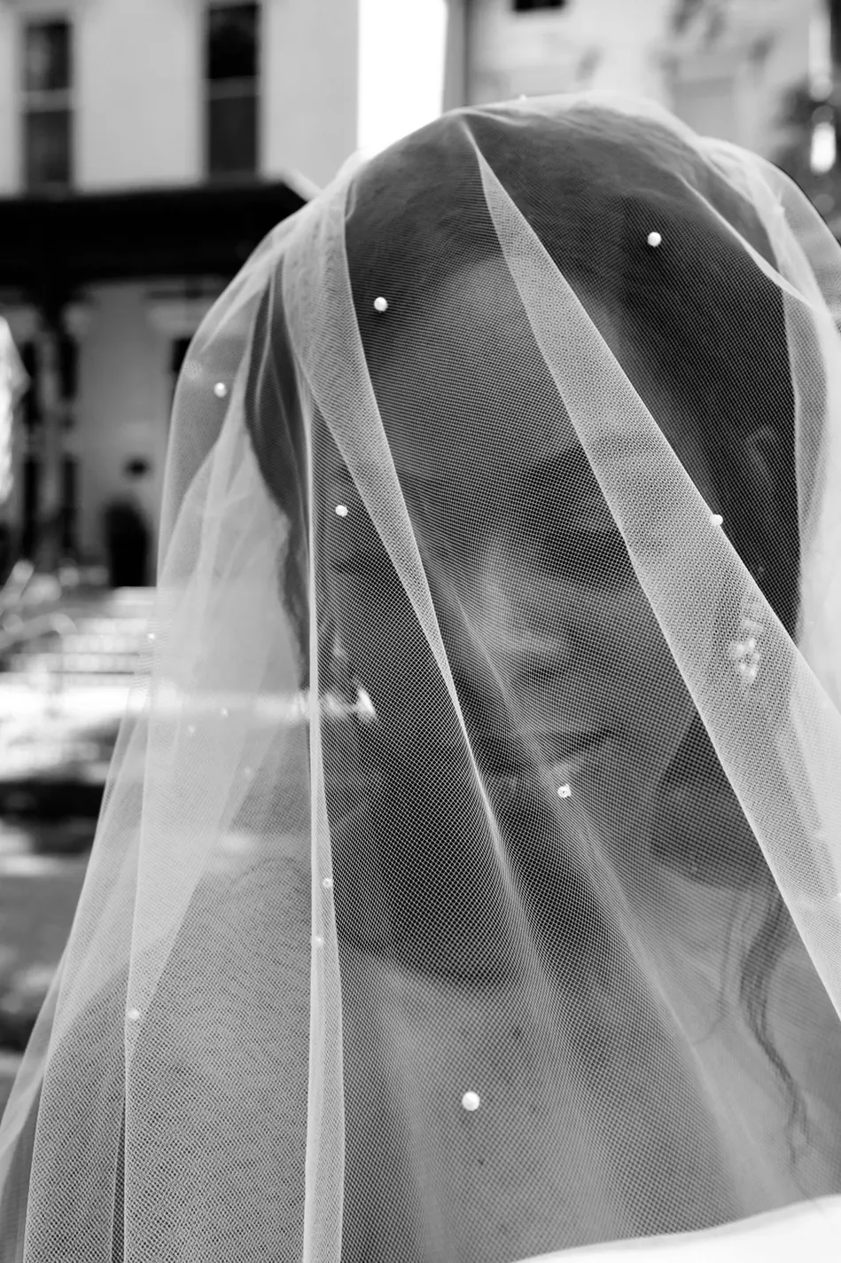 Close-up of sheer white veil with delicate pearl details.