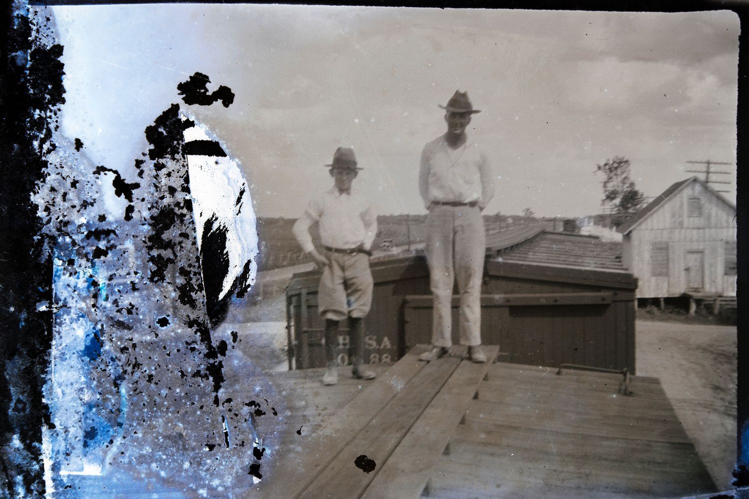 A damaged image of a man and boy standing on a train car.