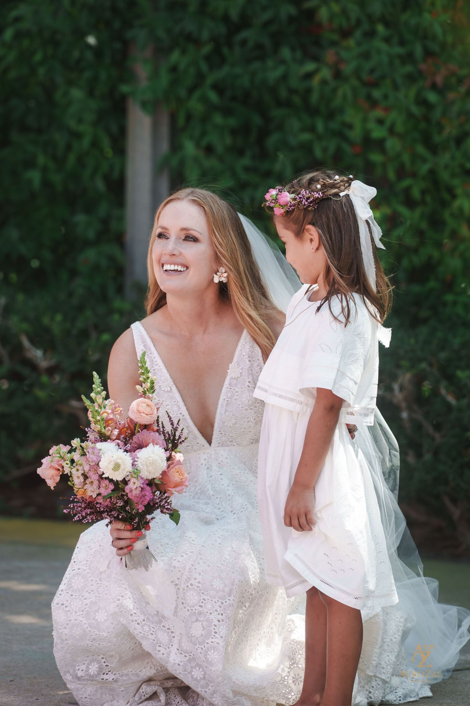 Wedding scene with flowing white dress and floral bouquet in natural light.