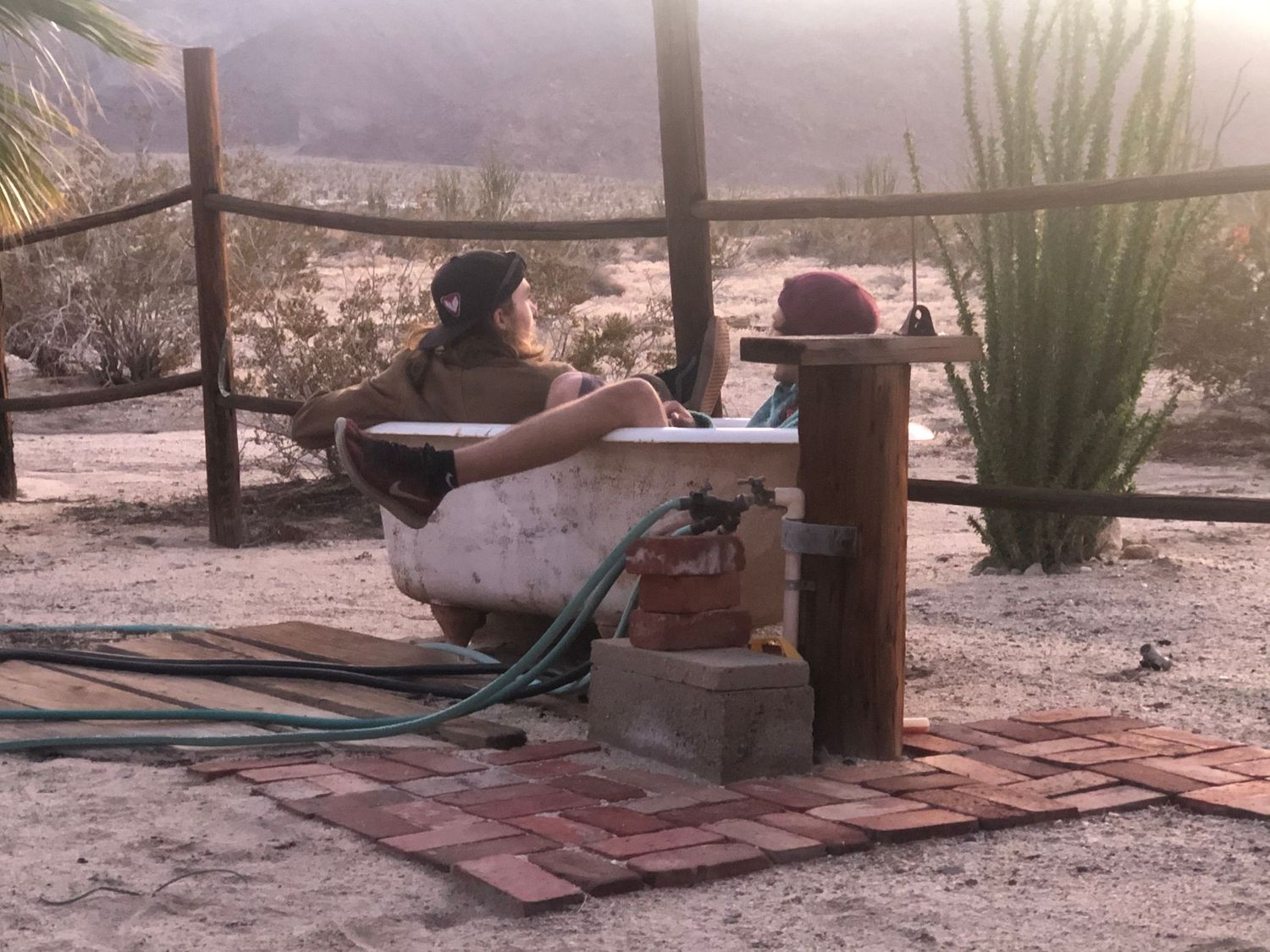 Desert patio setting with outdoor furniture and shade structures at dusk.