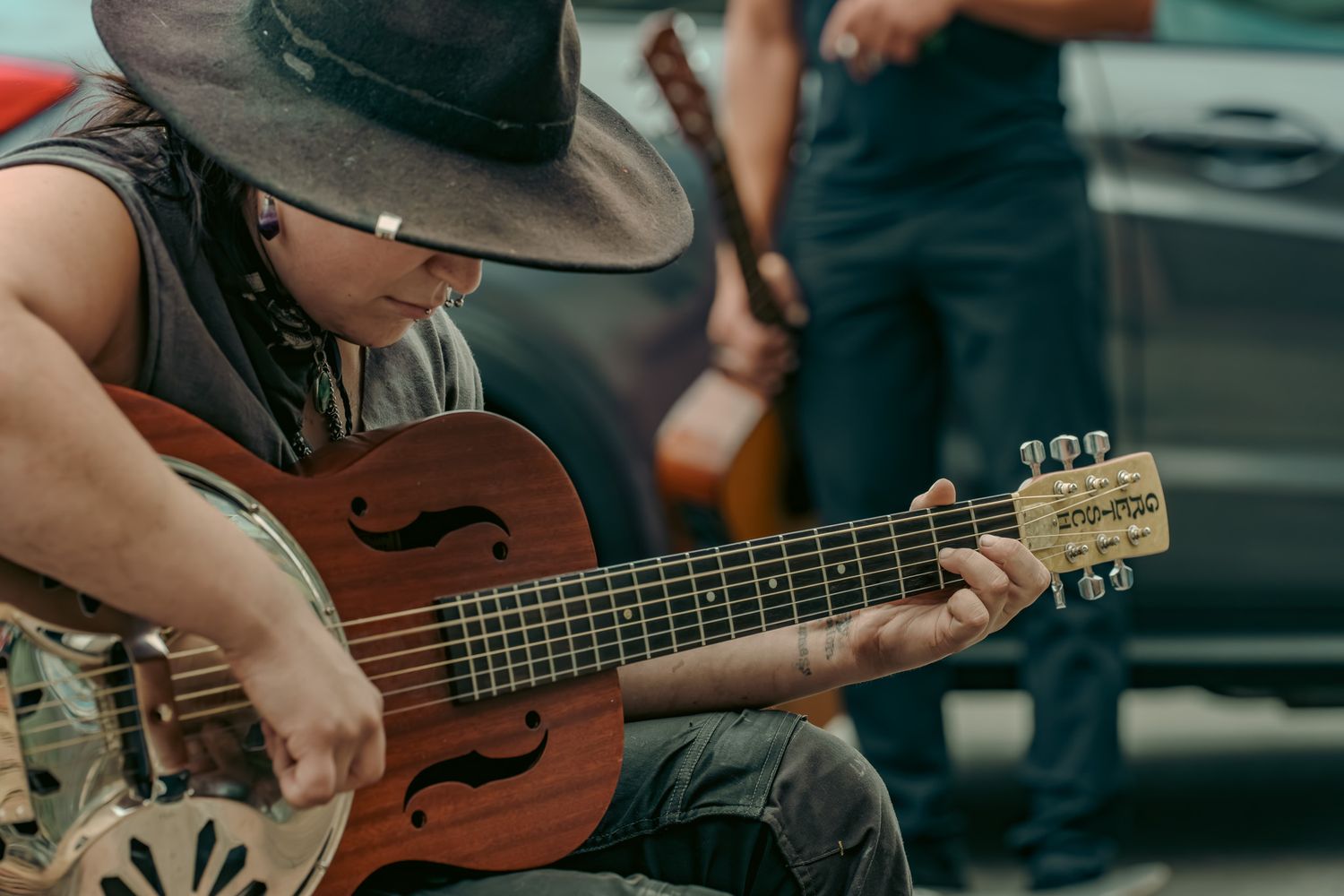 Musicians playing acoustic guitars and instruments in a casual indoor setting.