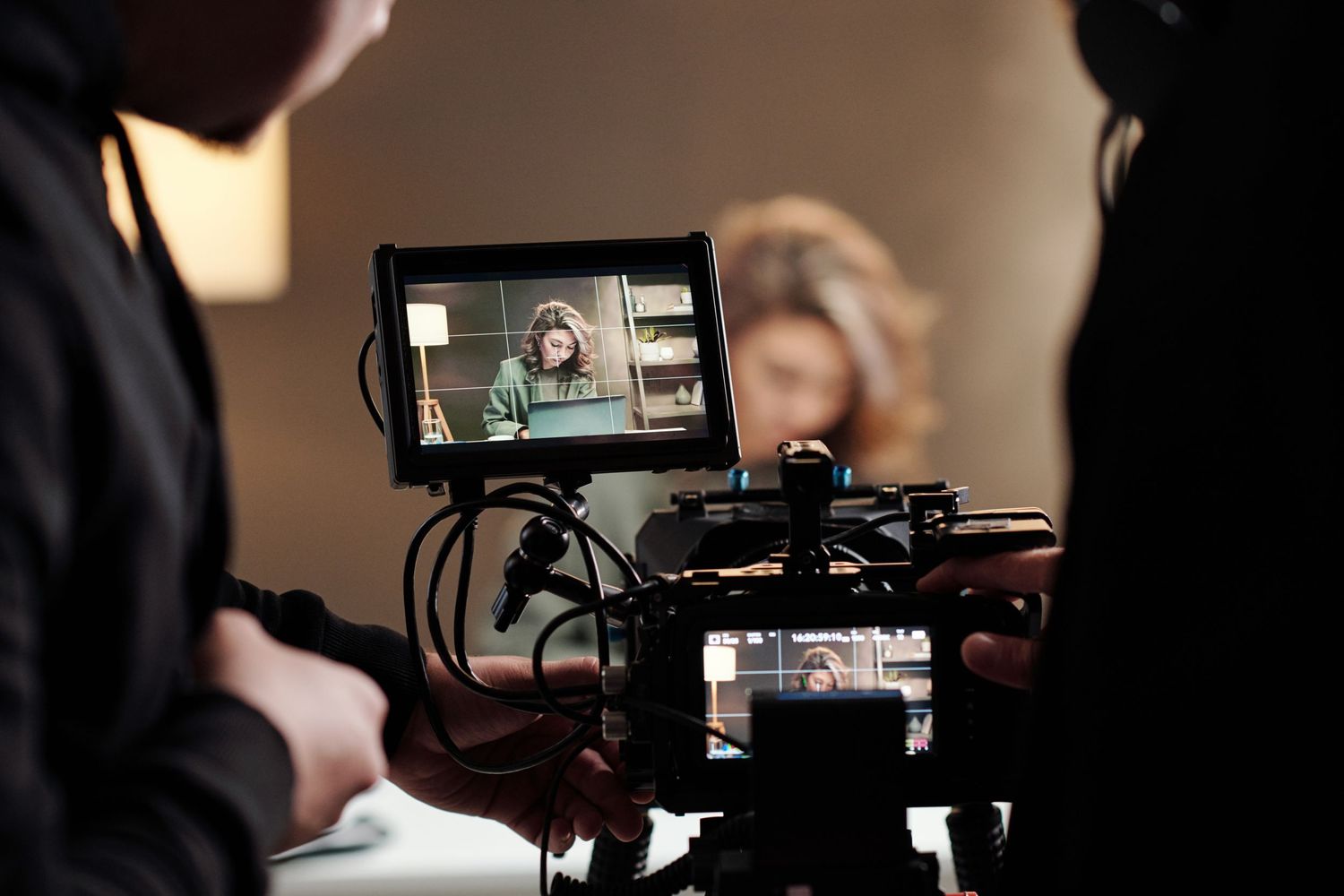 Behind-the-scenes film production with camera monitor showing actress being recorded on a professional movie set.