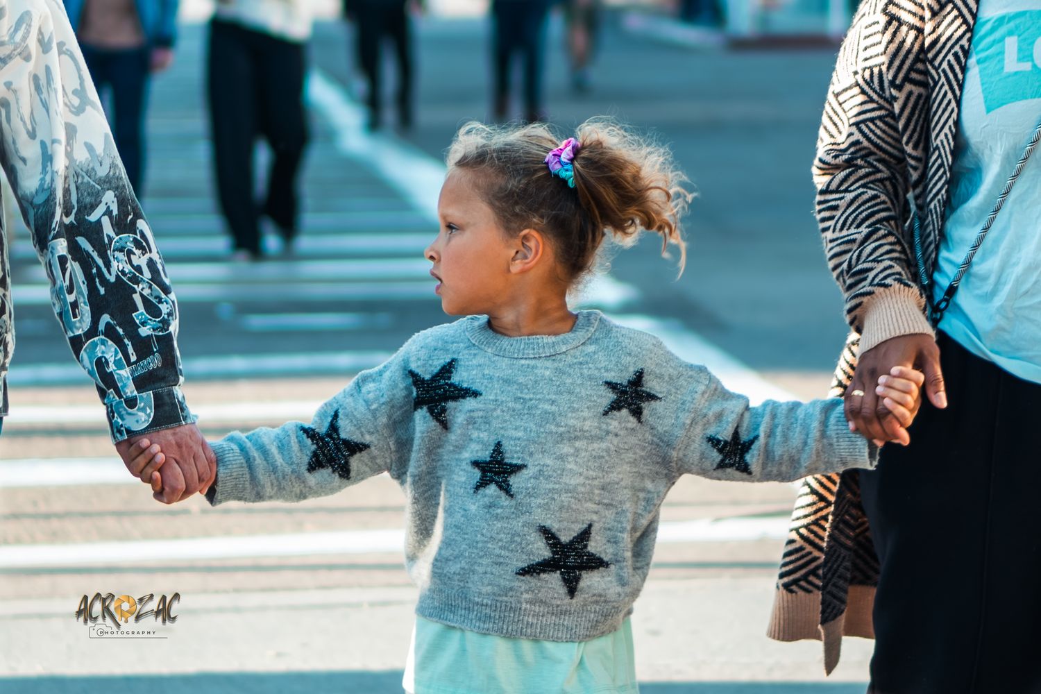 Child wearing star-patterned shirt plays outdoors in natural lighting.